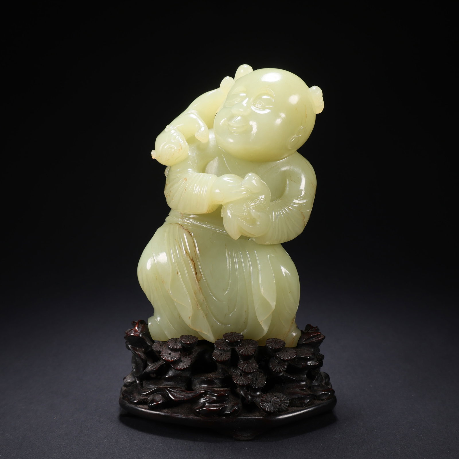 A TIANHUANG JADE CHILD FIGURINE ON WOODEN BASE: Tianhuang Jade Child Figurine on Wooden Base
