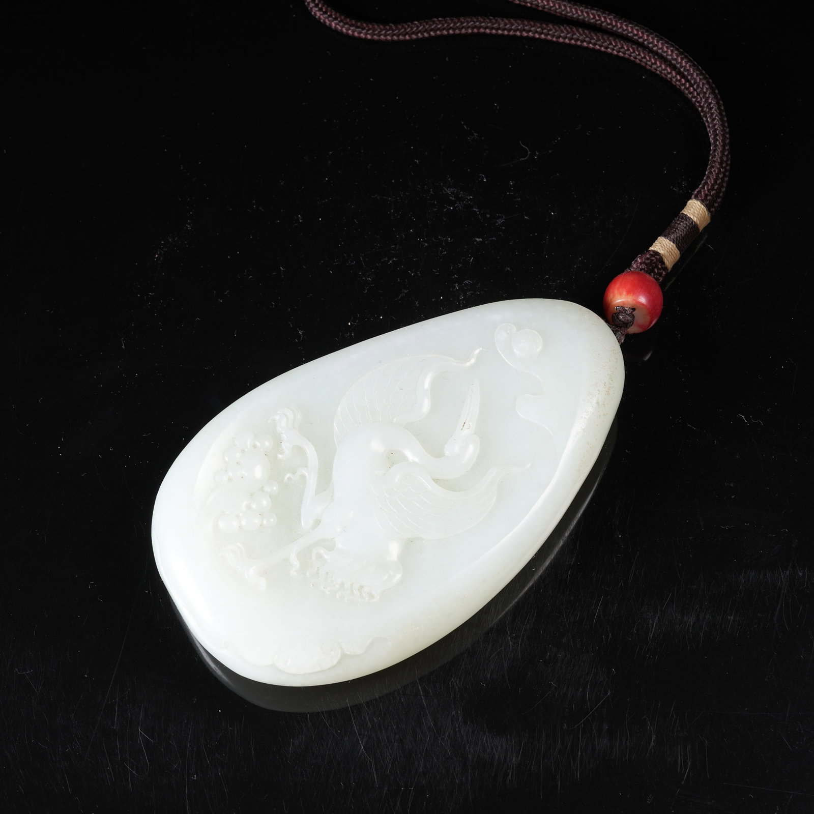 A HETIAN JADE PENDANT WITH CRANE PRESENTING LONGEVITY MOTIF: Hetian Jade Pendant with Crane Presenting Longevity Motif