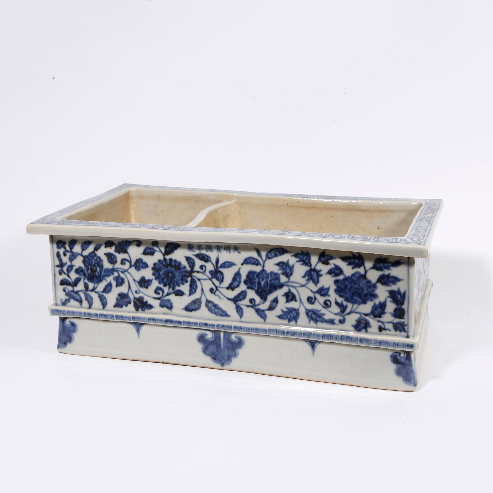 A BLUE AND WHITE MANGER-SHAPED VESSEL WITH INTERLOCKING FLORAL PATTERN: Blue and White Manger-shaped Vessel with Interlocking Floral Pattern
