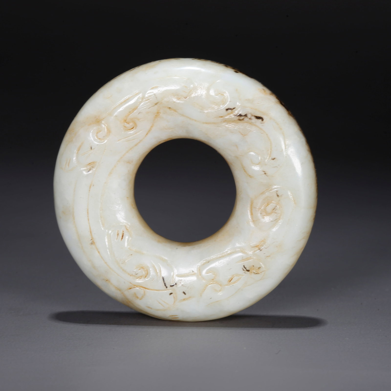 A CARVED HETIAN JADE BI DISC WITH BEAST PATTERN (1 of 9)