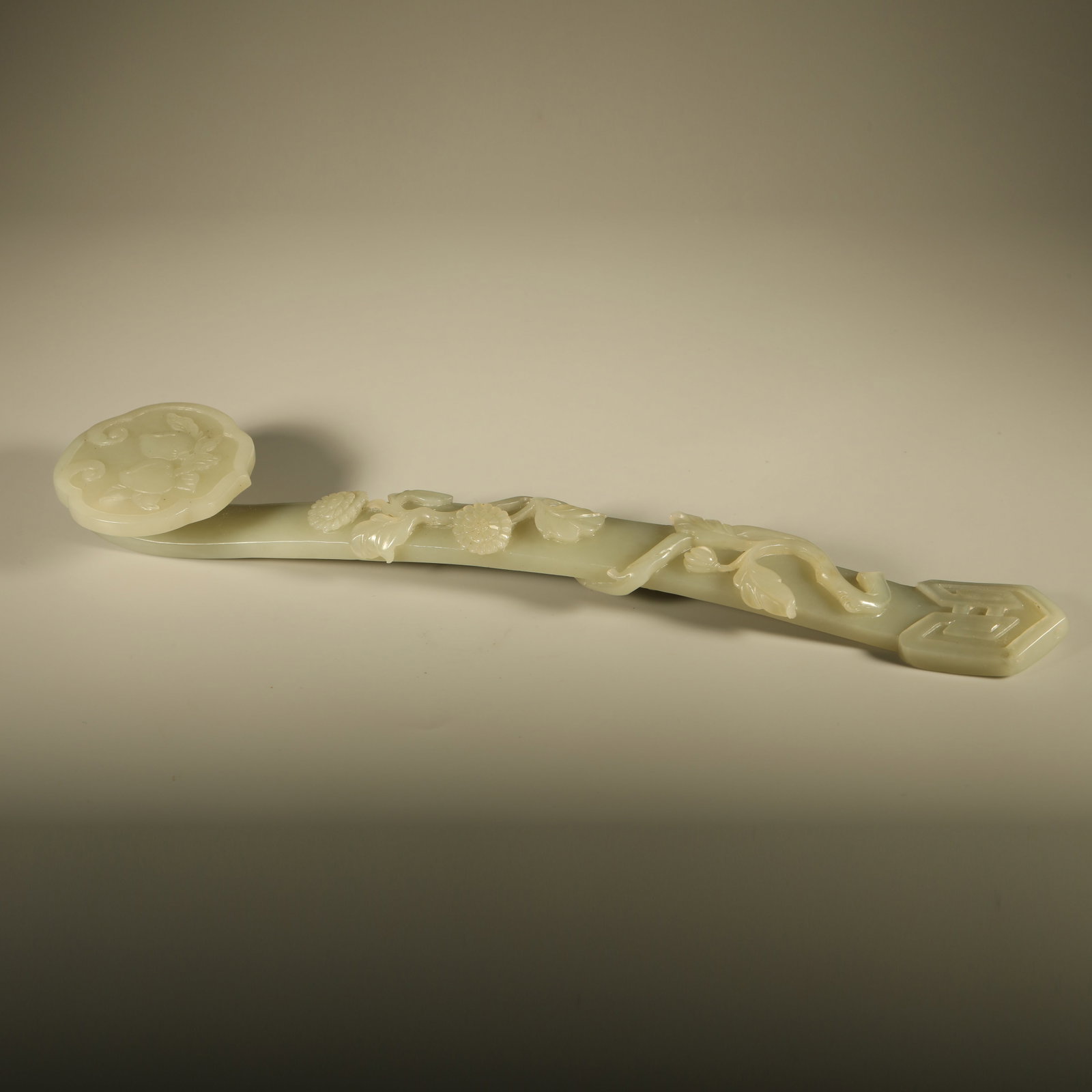 A HETIAN JADE RUYI CARVED WITH GANODERMA LONGEVITY MOTIF: Hetian Jade Ruyi Carved with Ganoderma Longevity Motif