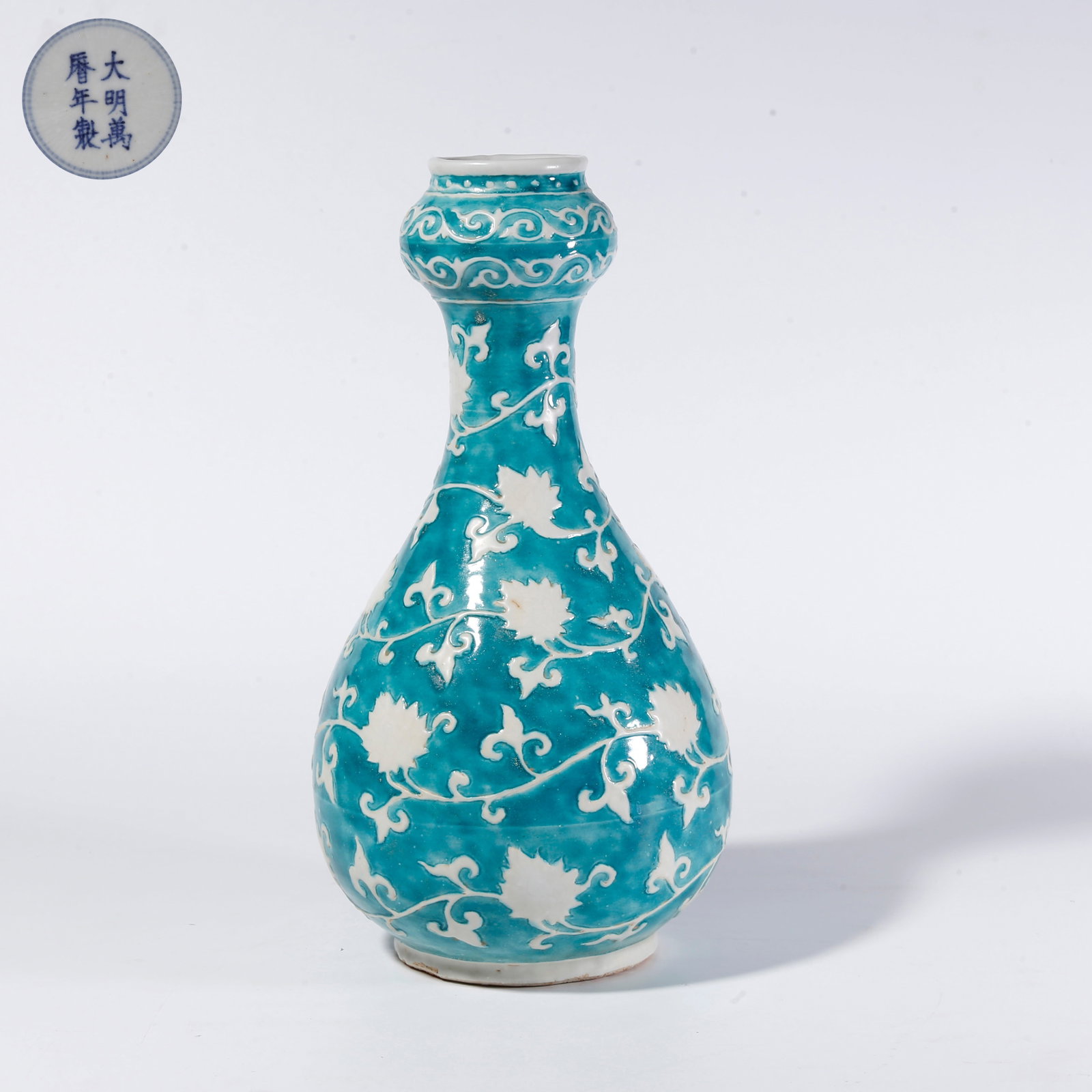 A TURQUOISE-GLAZED RESERVED WHITE FLORAL SCROLL GARLIC-SHAPED VASE: Turquoise-Glazed Reserved White Floral Scroll Garlic-Shaped Vase