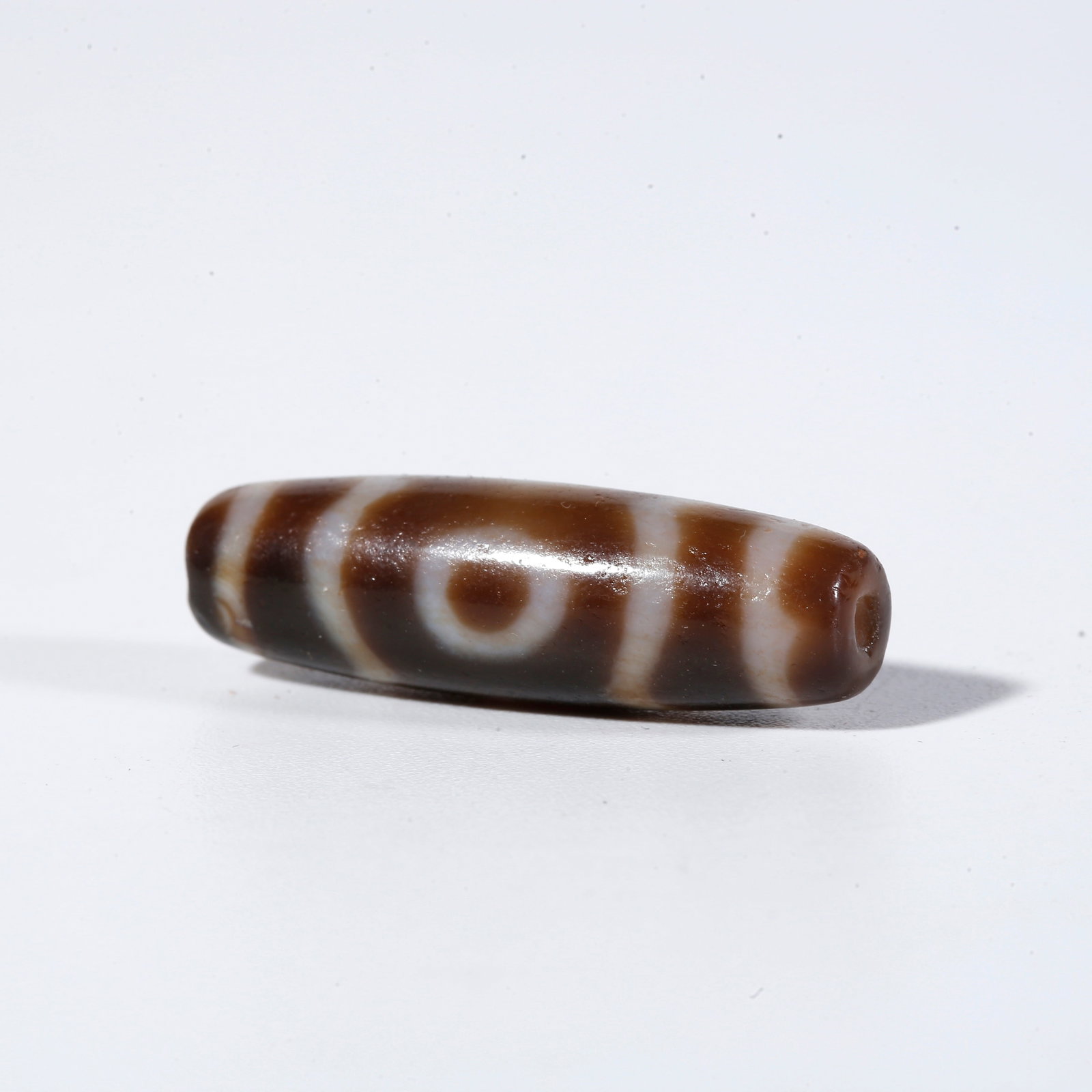 A THREE-EYED DZI BEAD: Three-Eyed Dzi Bead