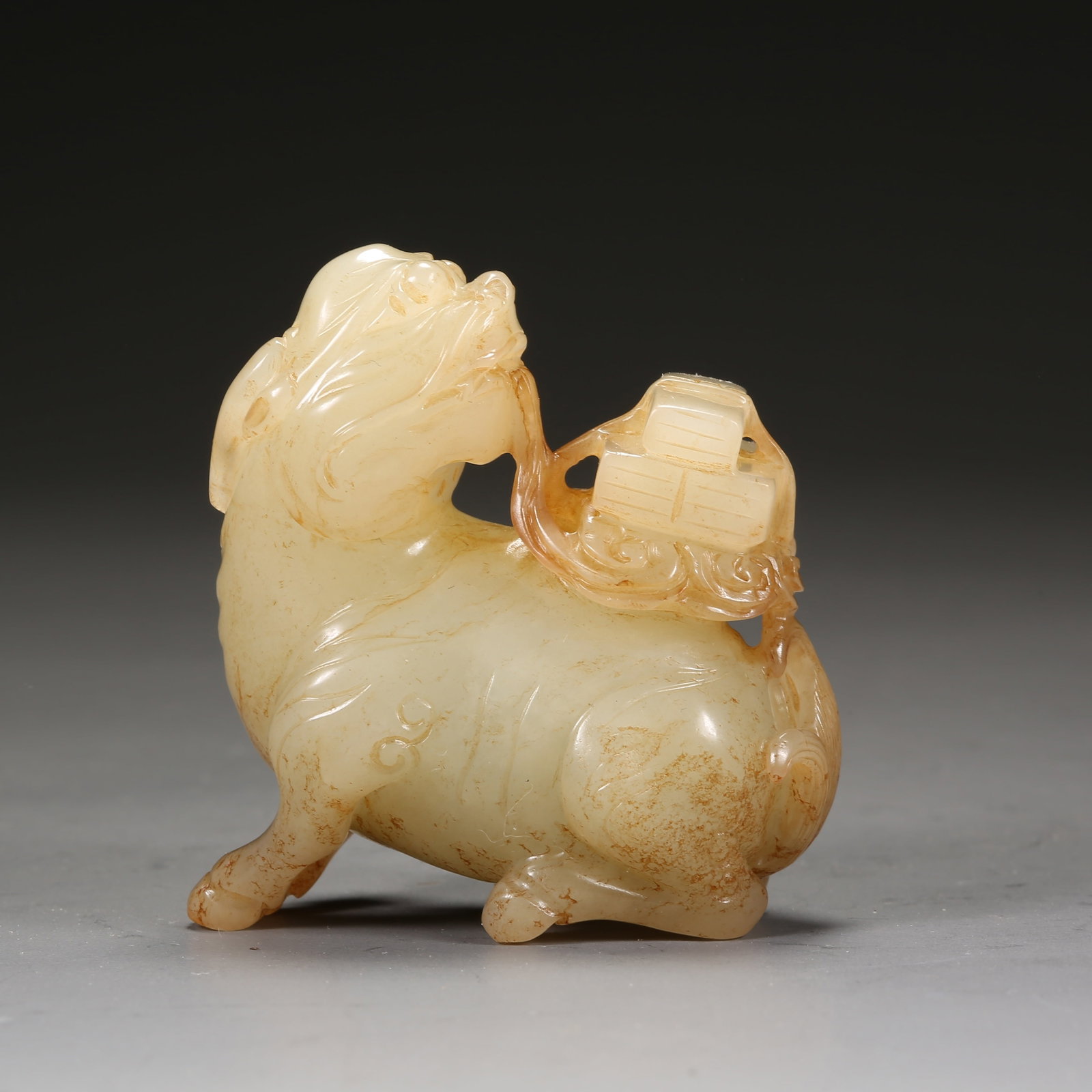A HETIAN JADE QILIN CARRYING A BOOK HANDLE: Hetian Jade Qilin Carrying a Book Handle
