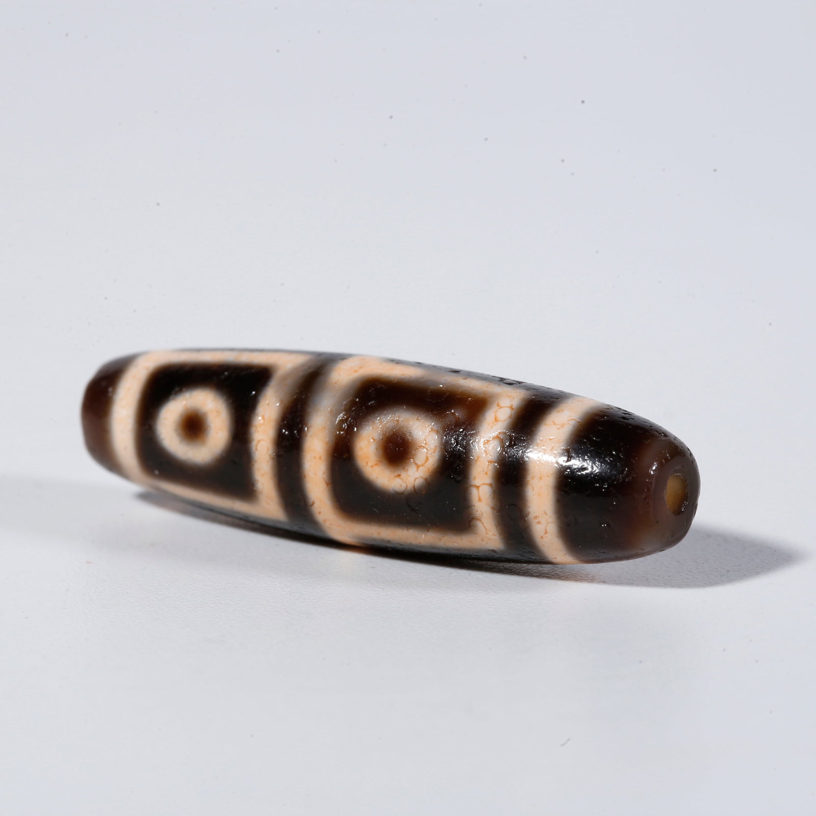 A FOUR-EYED DZI BEAD (1 of 9)