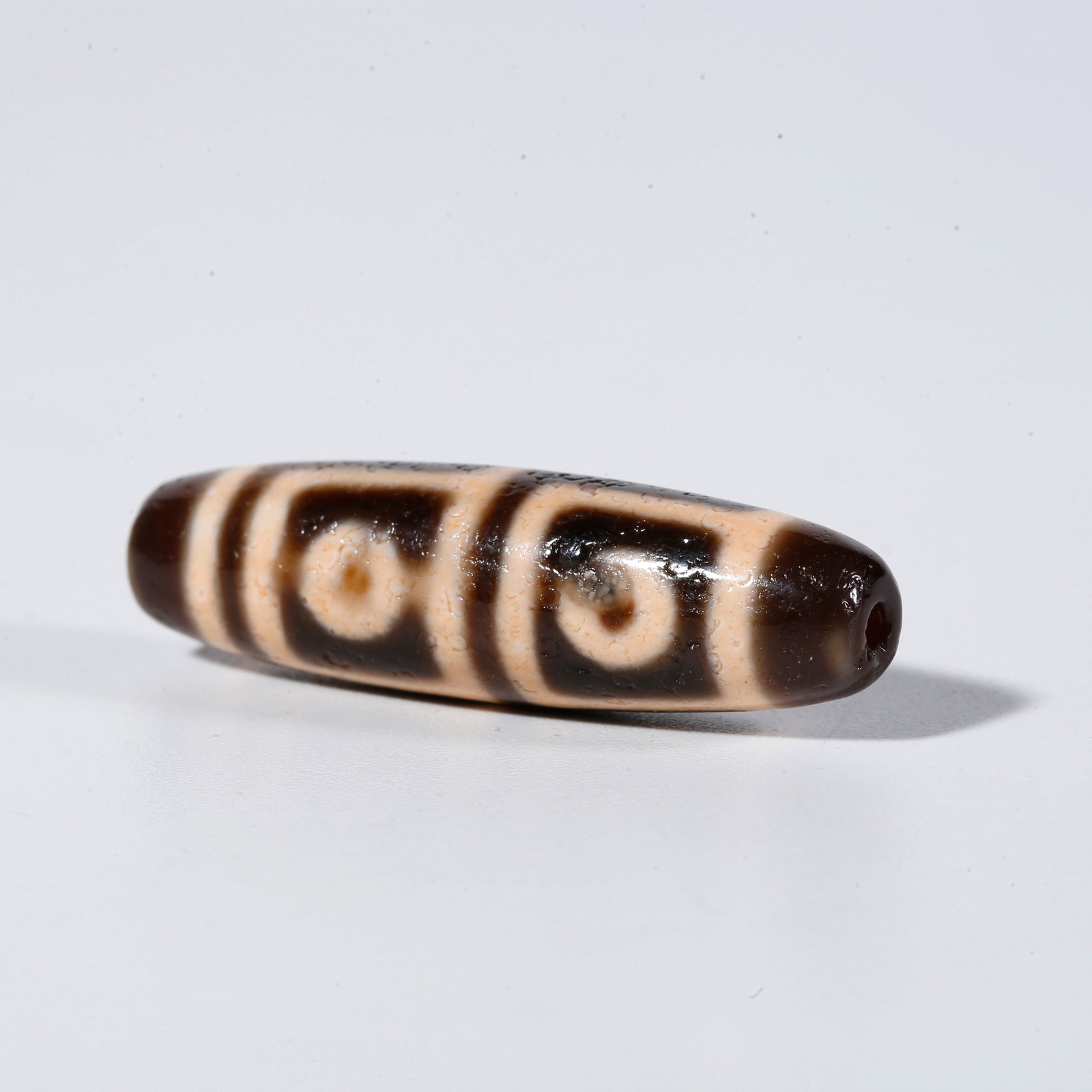 A FOUR-EYED DZI BEAD (1 of 9)