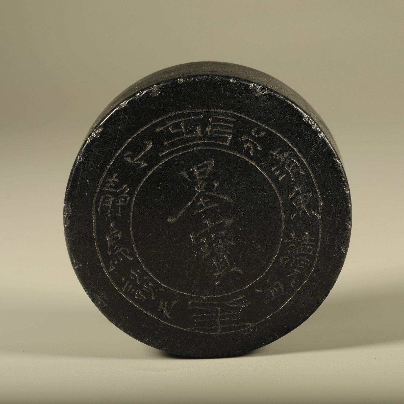 A JET STONE PAPERWEIGHT CARVED WITH INSCRIPTIONS: Jet stone paperweight carved with inscriptions