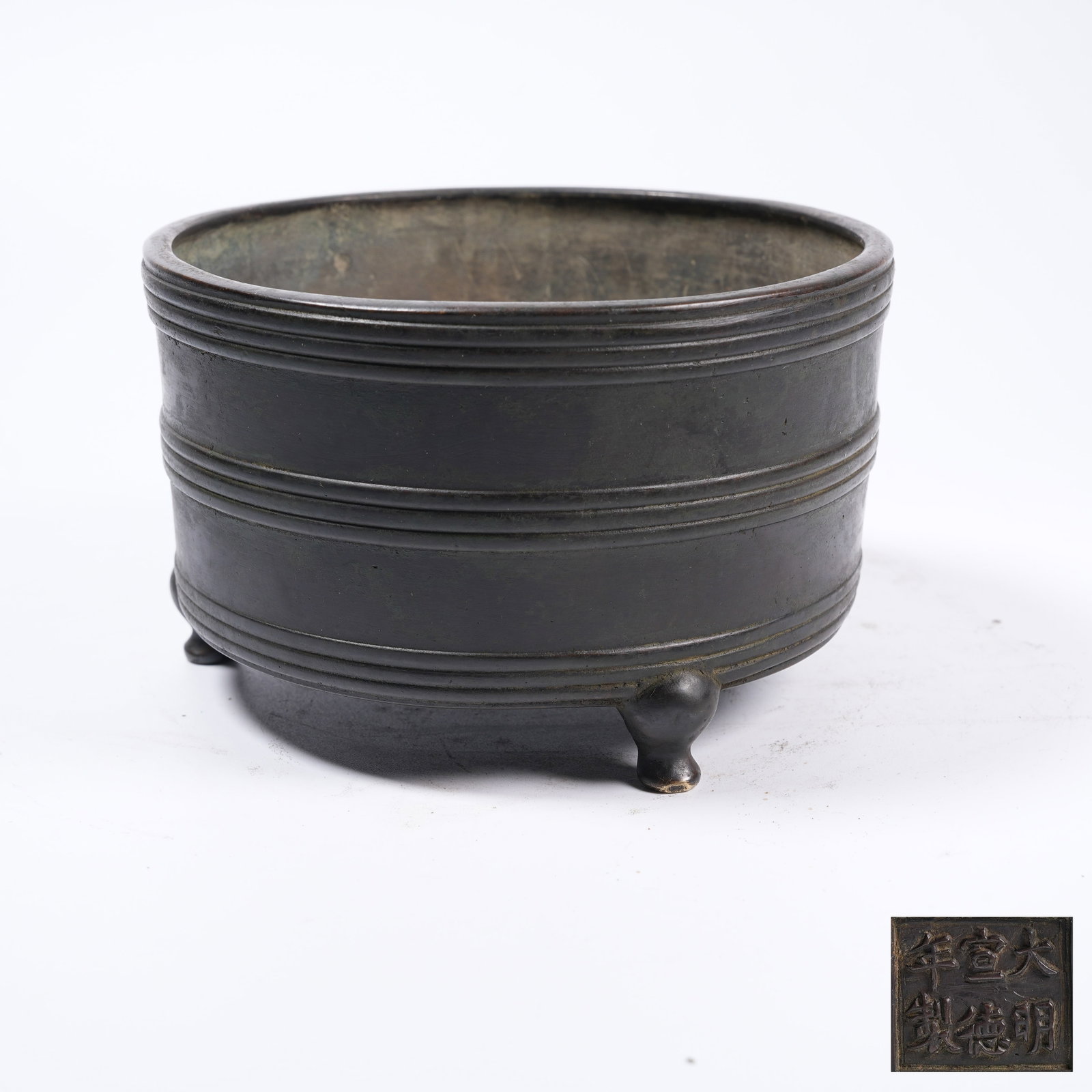 A BRONZE THREE-LEGGED CYLINDRICAL CENSER WITH STRING PATTERNS: Bronze Three-legged Cylindrical Censer with String Patterns