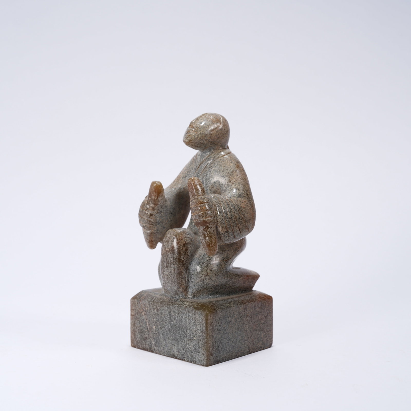 A ANCIENT JADE SEAL WITH KNEELING MUSICIAN FIGURE KNOB: Ancient jade seal with kneeling musician figure knob