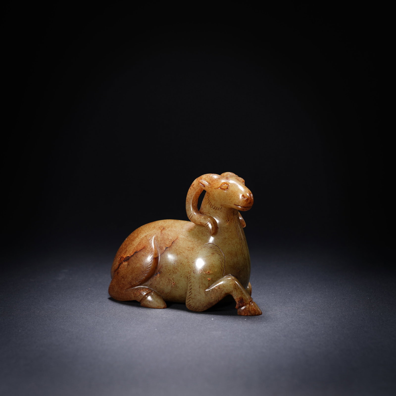 A ANCIENT JADE RECUMBENT RAM ORNAMENT: Ancient jade recumbent ram ornament