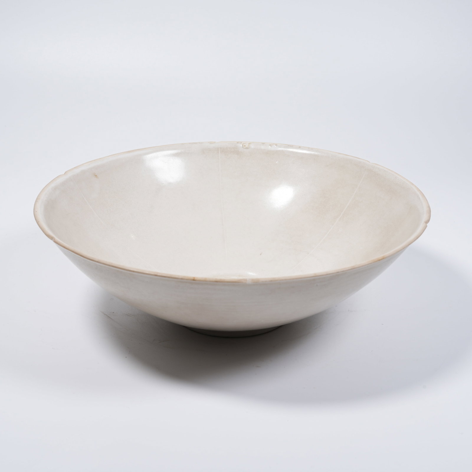 A DING KILN ROUND DRAGON PATTERN FLORAL-RIMMED BOWL (1 of 9)