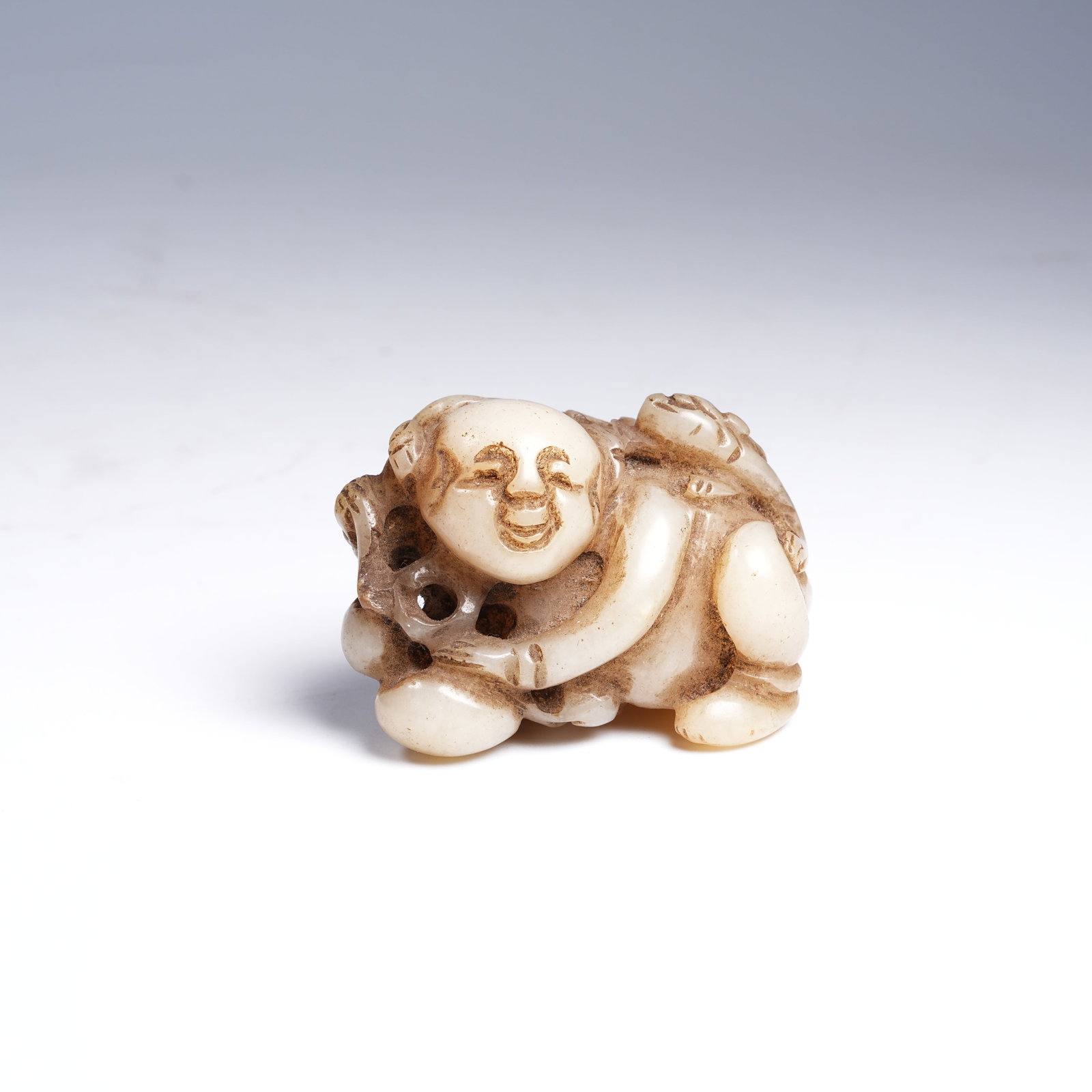 A HETIAN JADE BOY HOLDING LOTUS ORNAMENT: Hetian Jade Boy Holding Lotus Ornament