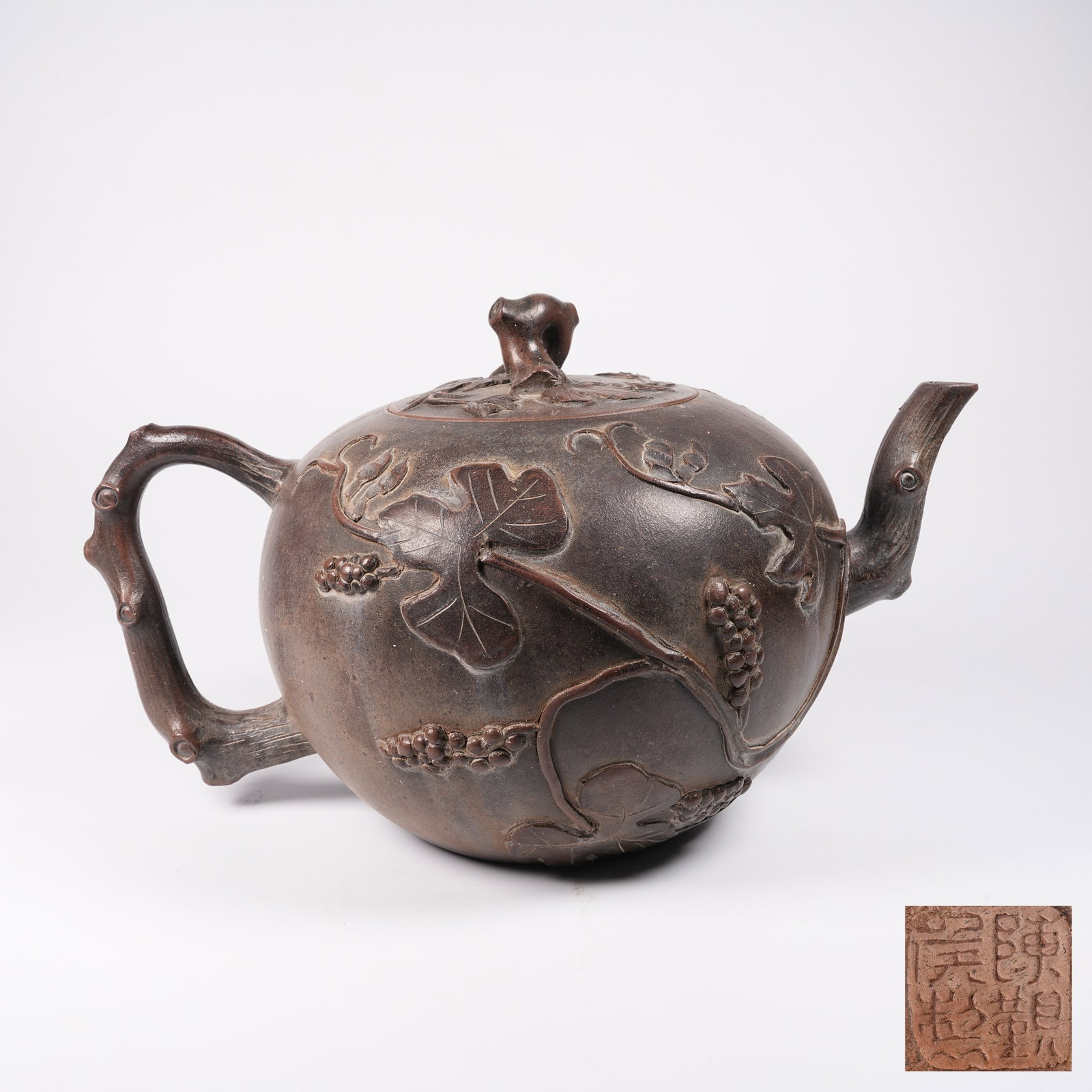 A YIXING ZISHA EWER WITH FLOWER AND AUSPICIOUS FRUIT PATTERN: Yixing Zisha Ewer with Flower and Auspicious Fruit Pattern