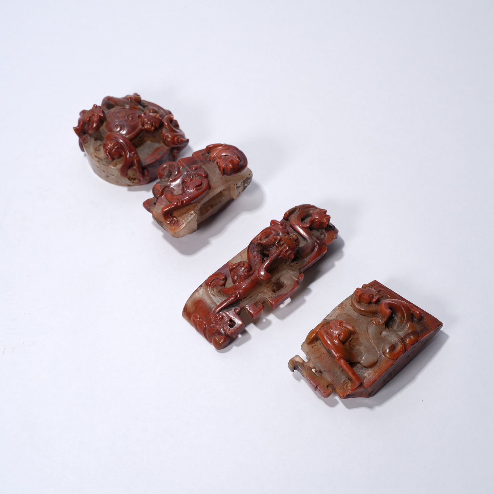 A WARRING STATES RED AGATE SWORD ORNAMENTS WITH CHI-DRAGON MOTIFS (SET): Warring States red agate sword ornaments with chi-dragon motifs (set)