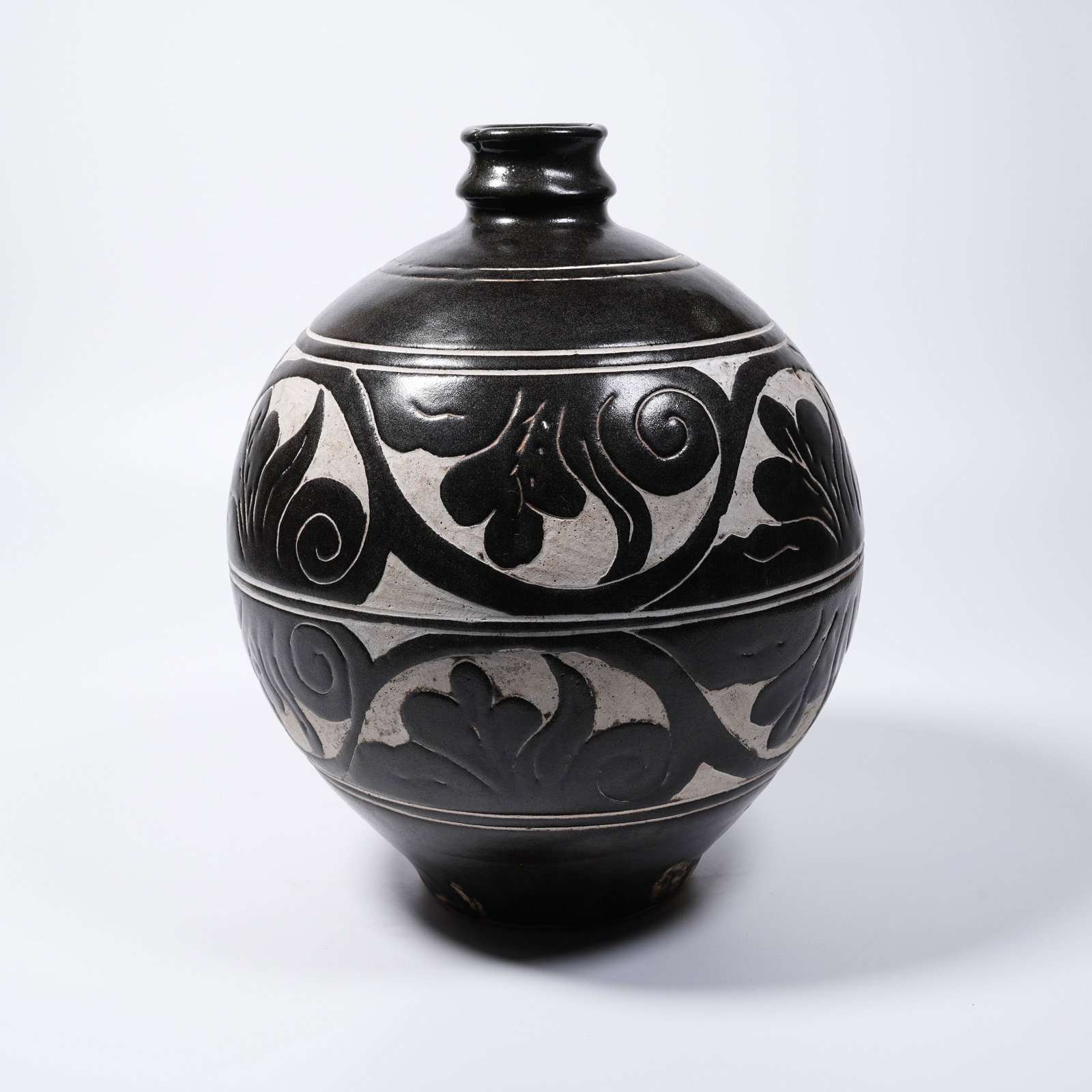 A CIZHOU KILN CARVED POWDER-FILLED FLOWER-BUDDING VASE: Cizhou Kiln Carved Powder-filled Flower-budding Vase