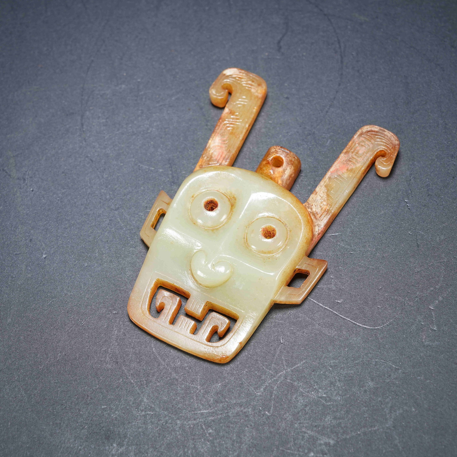 A ARCHAIC JADE OPENWORK PENDANT WITH DIVINE HUMAN FACE: Archaic jade openwork pendant with divine human face