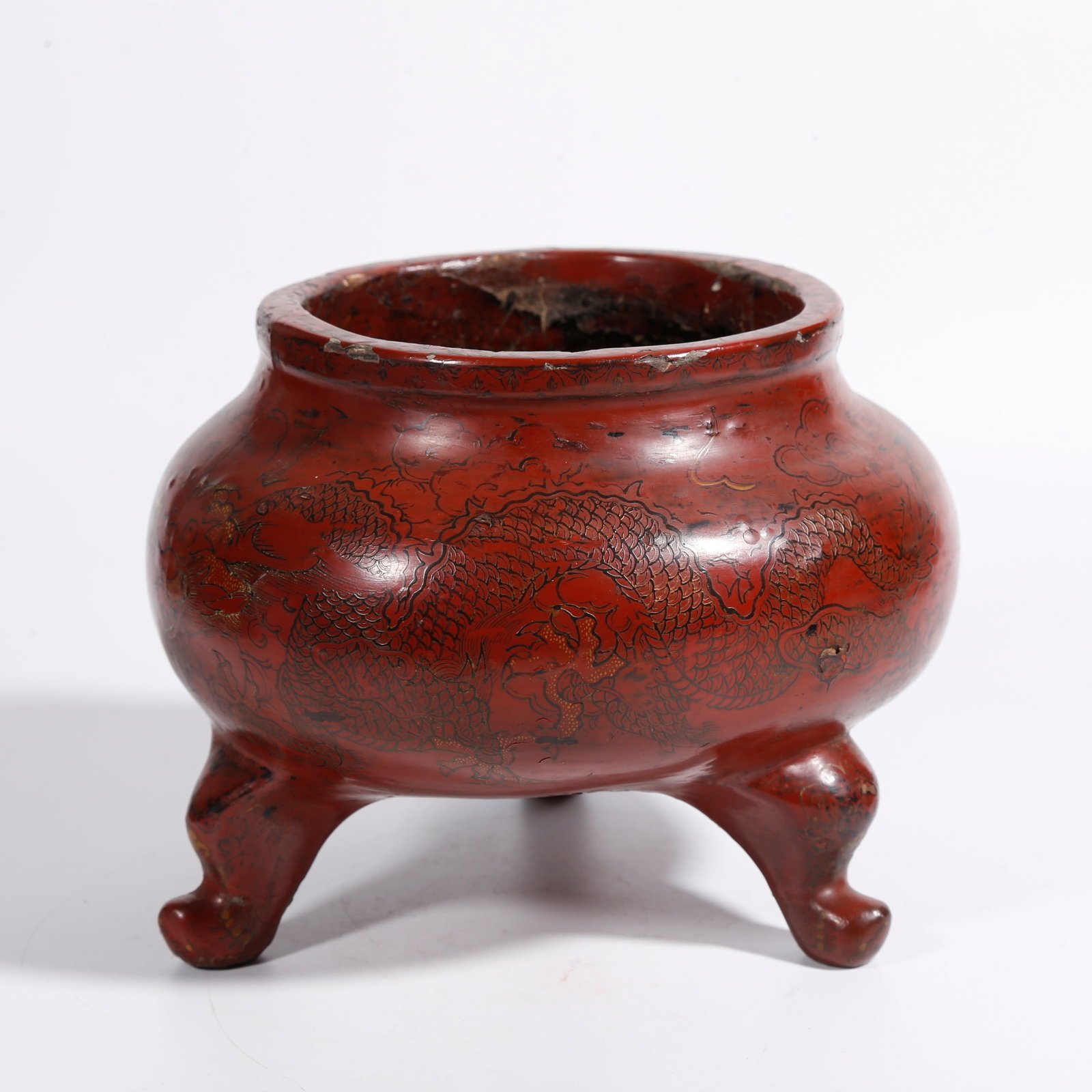 A CARVED RED LACQUER THREE-LEGGED INCENSE BURNER WITH CLOUD AND DRAGON PATTERN: Carved Red Lacquer Three-legged Incense Burner with Cloud and Dragon Pattern