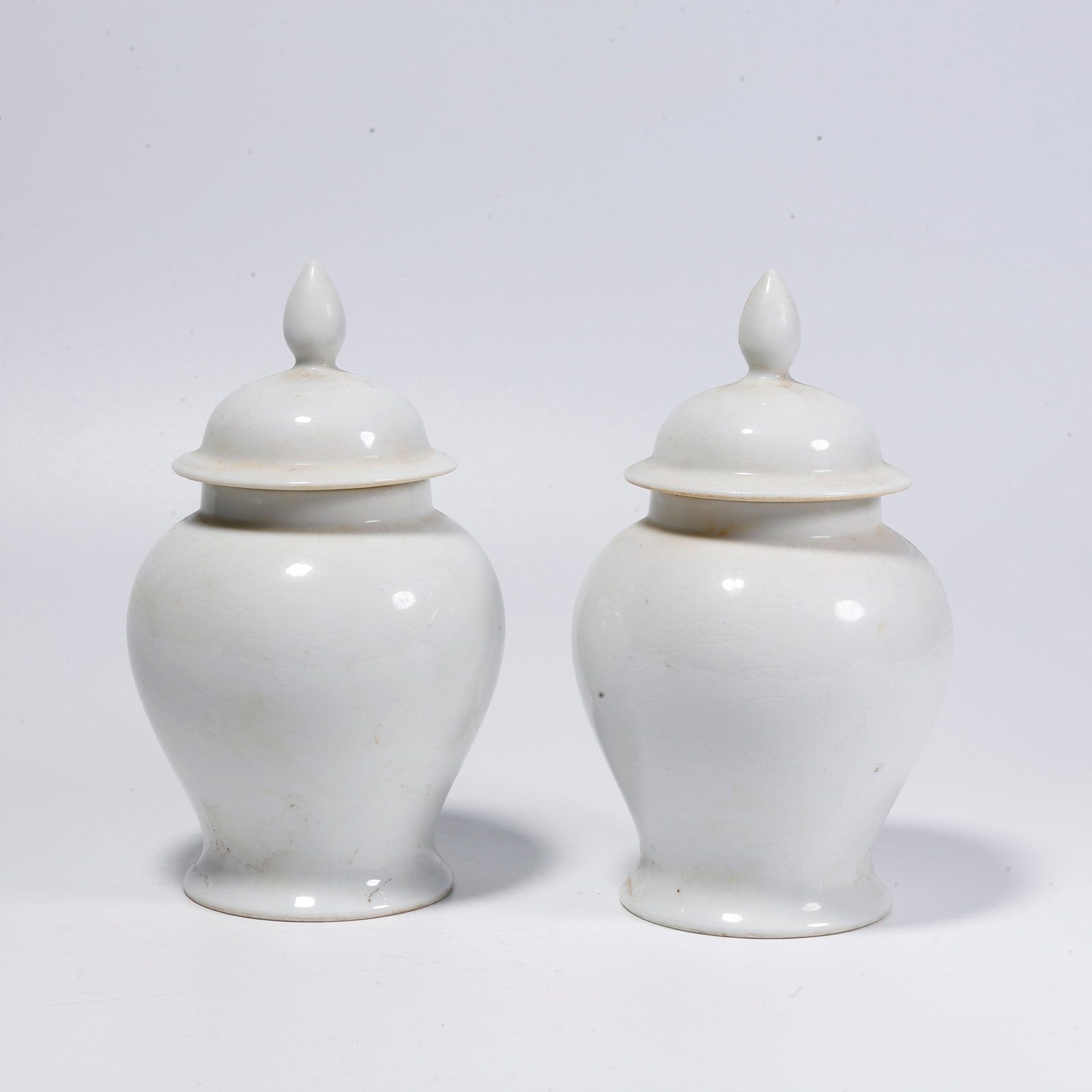 A DEHUA WHITE PORCELAIN COVERED JAR WITH CLOUD AND DRAGON PATTERN (PAIR): Dehua White Porcelain Covered Jar with Cloud and Dragon Pattern (Pair)