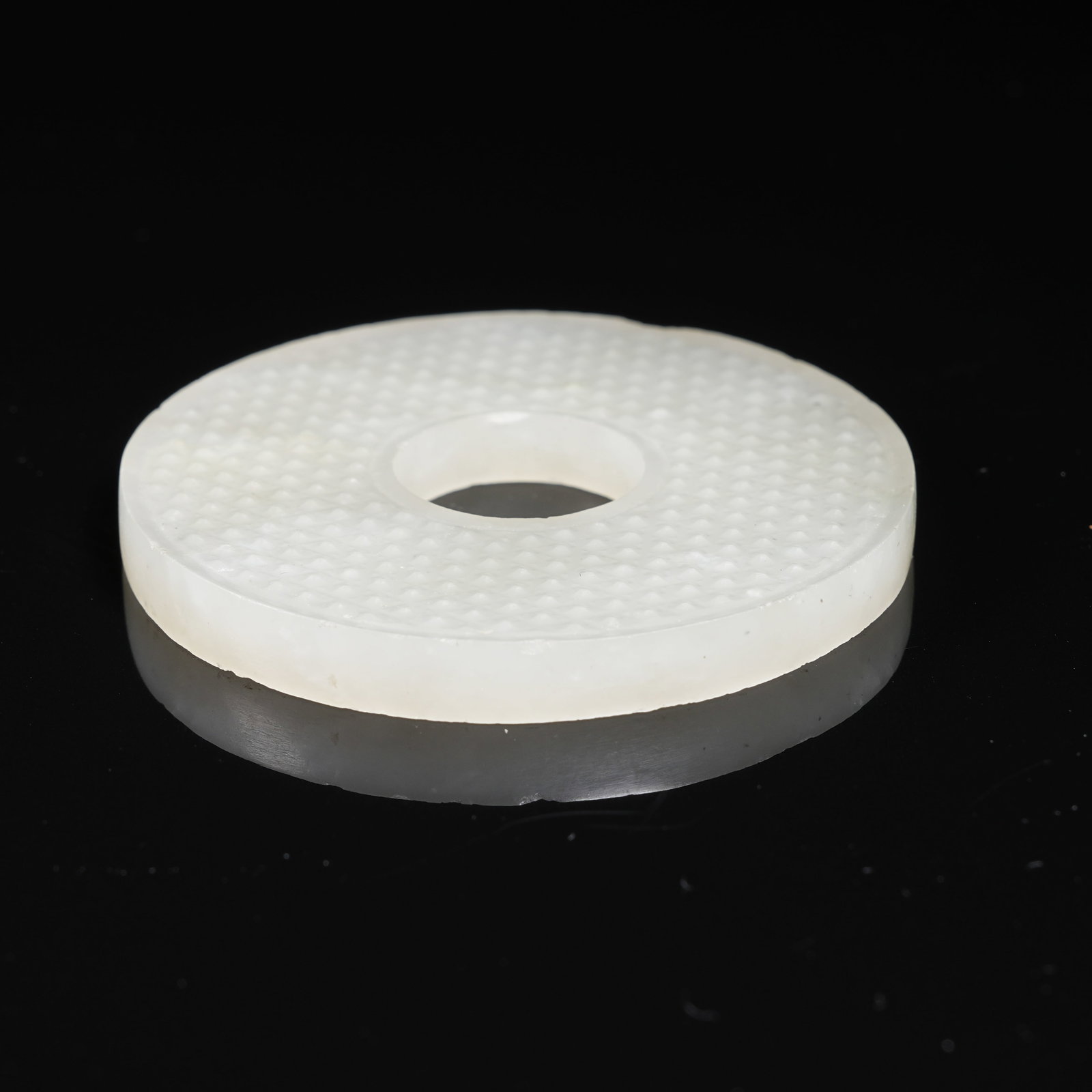 A NEPHRITE BI DISC WITH STUD PATTERN - 9