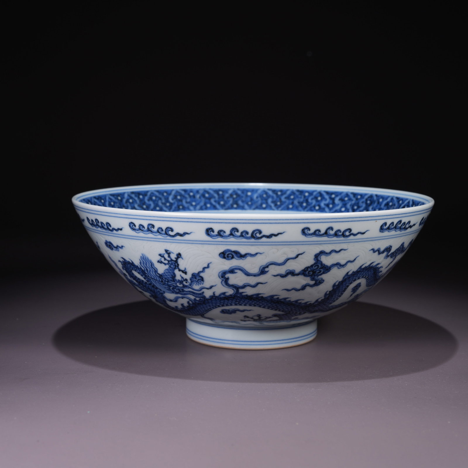 A LARGE BLUE-AND-WHITE BOWL WITH CLOUD AND DRAGON MOTIF: Large Blue-and-White Bowl with Cloud and Dragon Motif