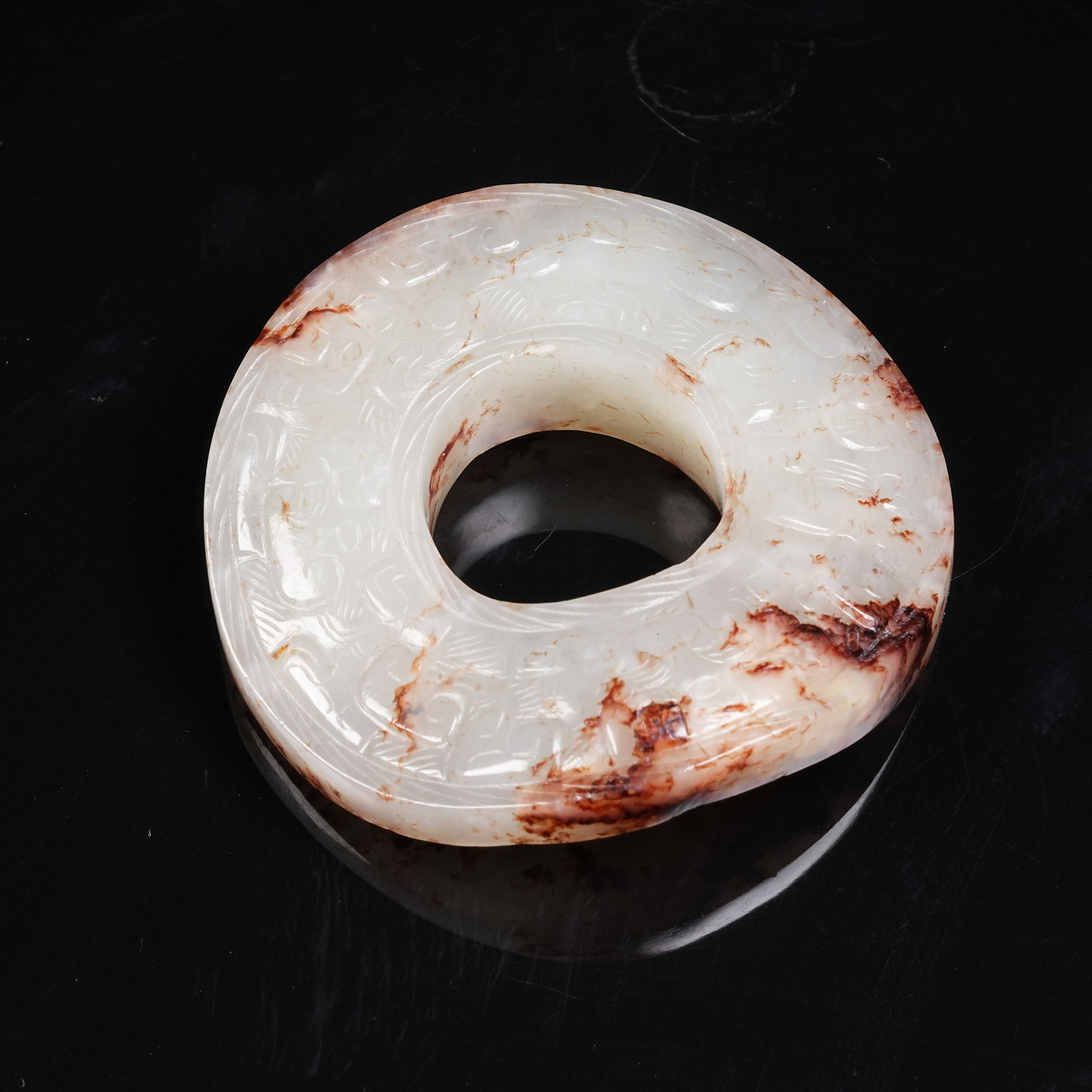 A ARCHAIC JADE BI DISC WITH INTERLOCKING CLOUD PATTERN: Archaic Jade Bi Disc with Interlocking Cloud Pattern