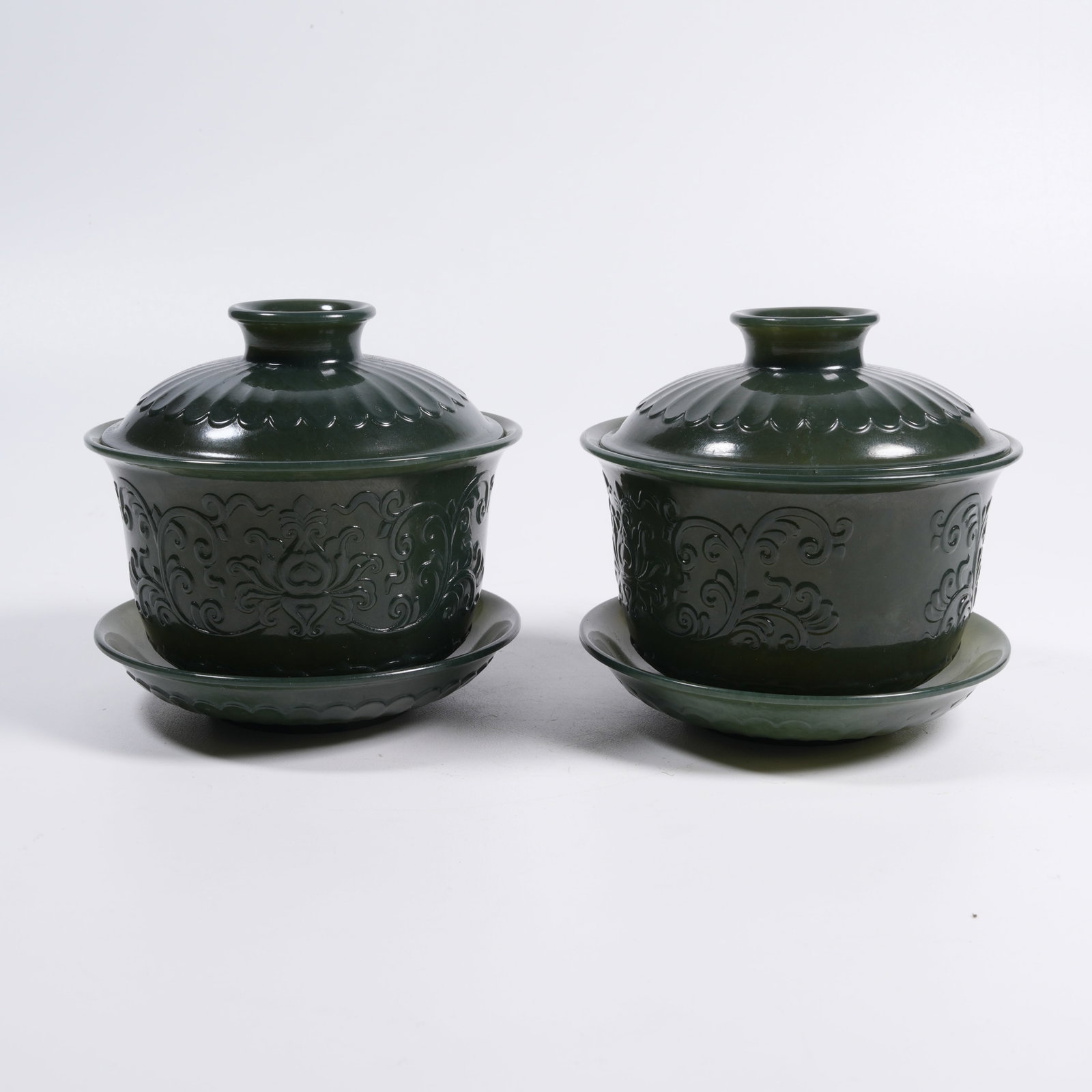 A SET OF HETIAN GREEN JADE CUP SAUCERS WITH INTERLOCKING FLORAL PATTERN: Set of Hetian Green Jade Cup Saucers with Interlocking Floral Pattern