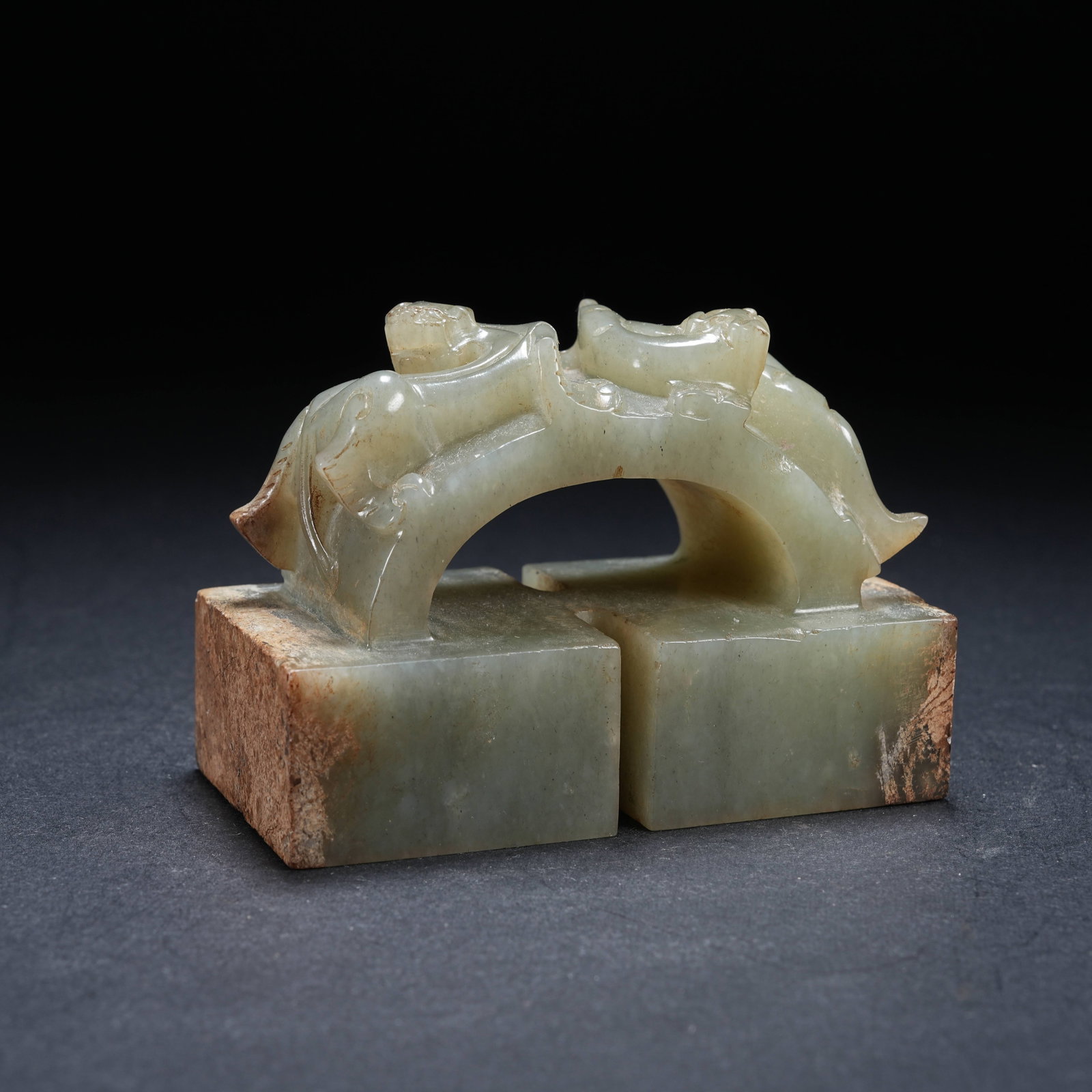 A ARCHAIC JADE ARCH-SHAPED SEAL WITH DRAGON KNOB: Archaic jade arch-shaped seal with dragon knob