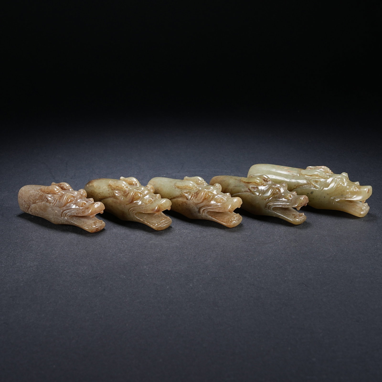 A SET OF FIVE ARCHAIC JADE DRAGON HEADS: Set of five archaic jade dragon heads