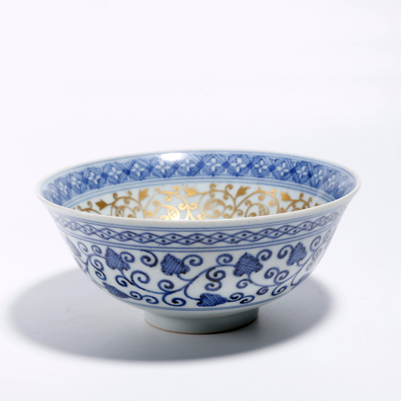 A GOLD-TRACED INTERLOCKING FLORAL PATTERN BLUE AND WHITE BOWL: Gold-traced Interlocking Floral Pattern Blue and White Bowl