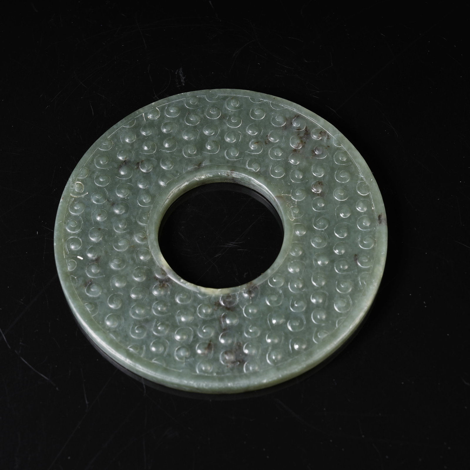 A GREEN NEPHRITE BI DISC WITH INTERLOCKING CLOUD PATTERN: Green Nephrite Bi Disc with Interlocking Cloud Pattern