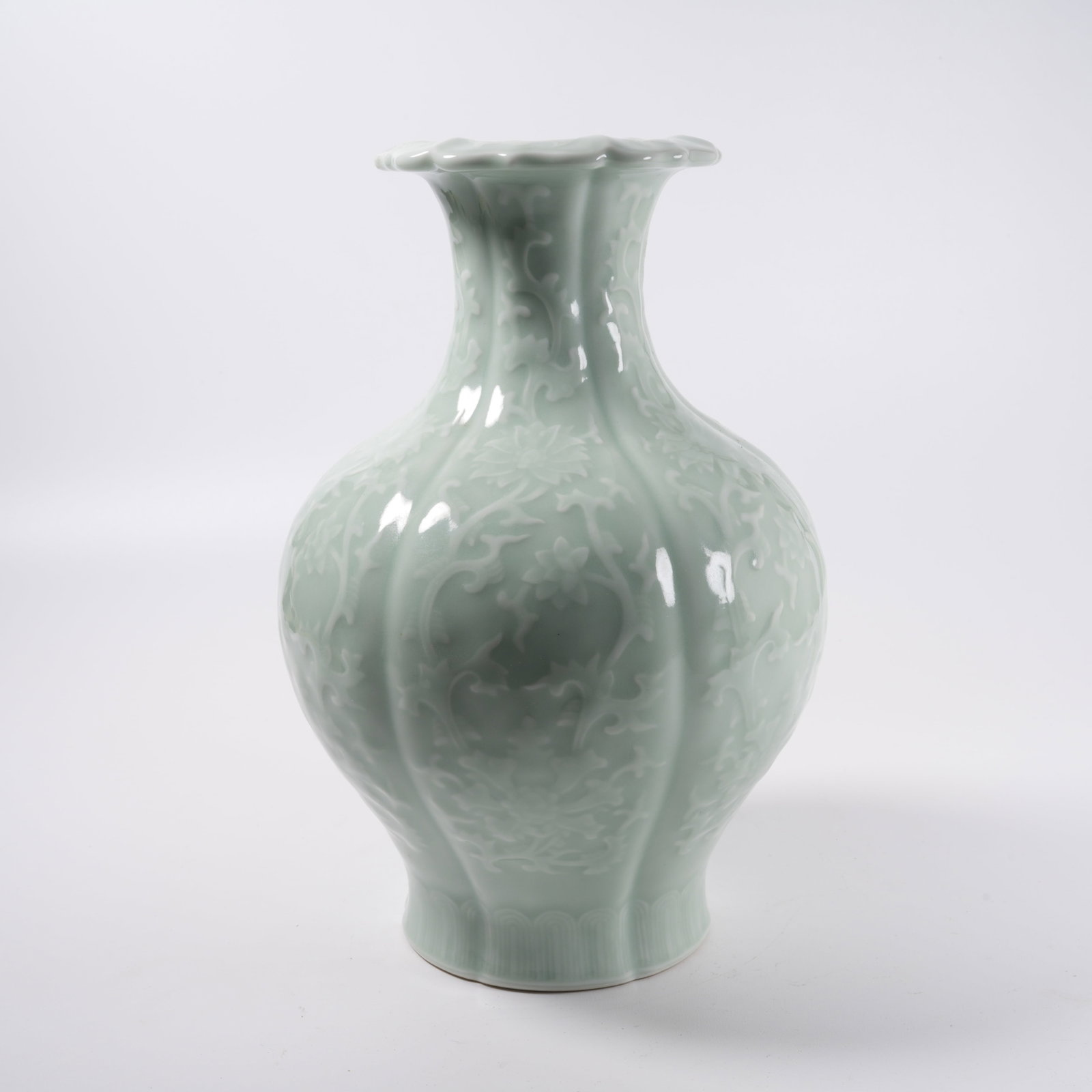 A PINK CELADON GLAZE FLORAL RIM ZUN WITH CARVED INTERLOCKING FLORAL PATTERN: Pink Celadon Glaze Floral Rim Zun with Carved Interlocking Floral Pattern