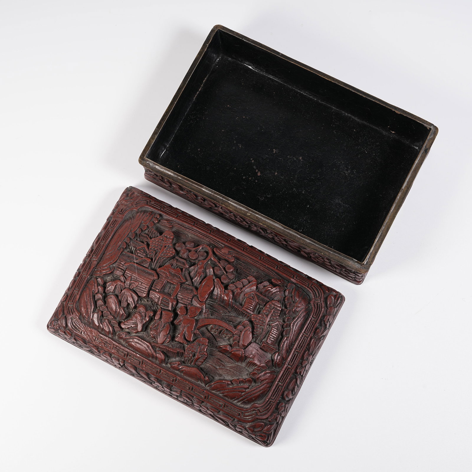 A CARVED RED LACQUER COVERED BOX WITH LANDSCAPE AND PAVILION PATTERN: Carved Red Lacquer Covered Box with Landscape and Pavilion Pattern