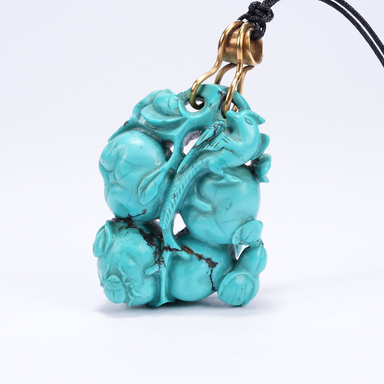 A TURQUOISE PENDANT WITH AUSPICIOUS FRUIT AND DIVINE BIRD PATTERN: Turquoise Pendant with Auspicious Fruit and Divine Bird Pattern