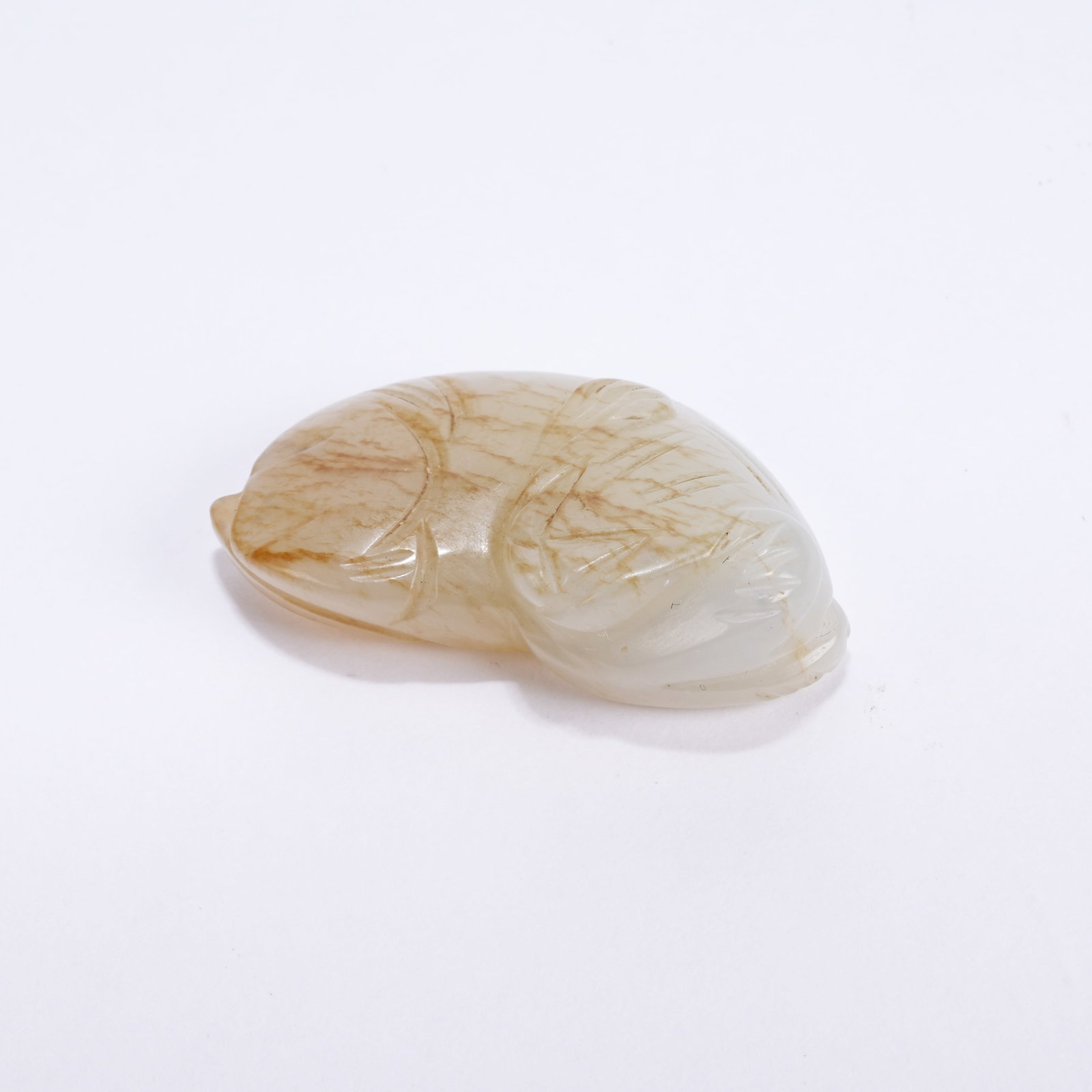 A HETIAN JADE RECUMBENT BEAST PENDANT: Hetian Jade Recumbent Beast Pendant