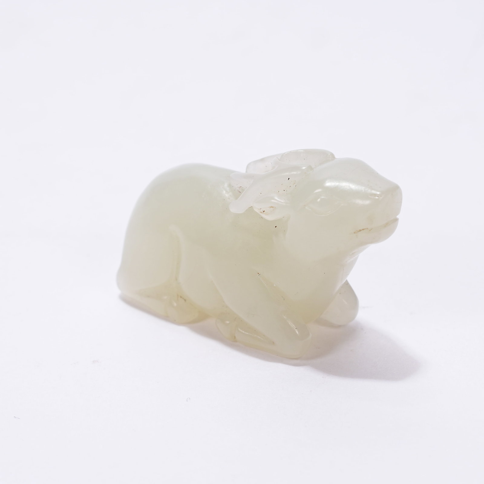 A HETIAN JADE RECLINING DEER PENDANT: Hetian Jade Reclining Deer Pendant