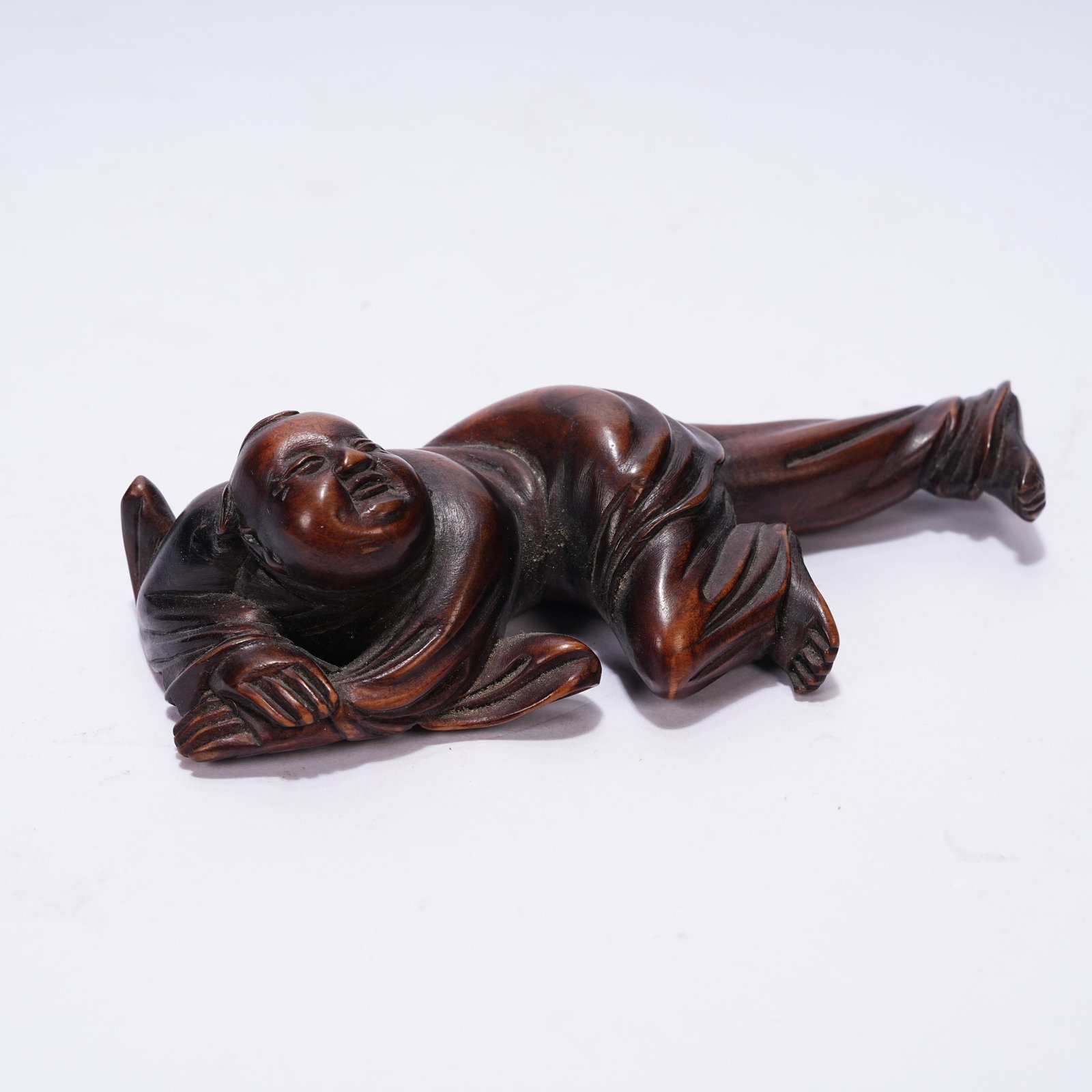 A HUANGHUALI RECLINING CHILD ORNAMENT: Huanghuali Reclining Child Ornament