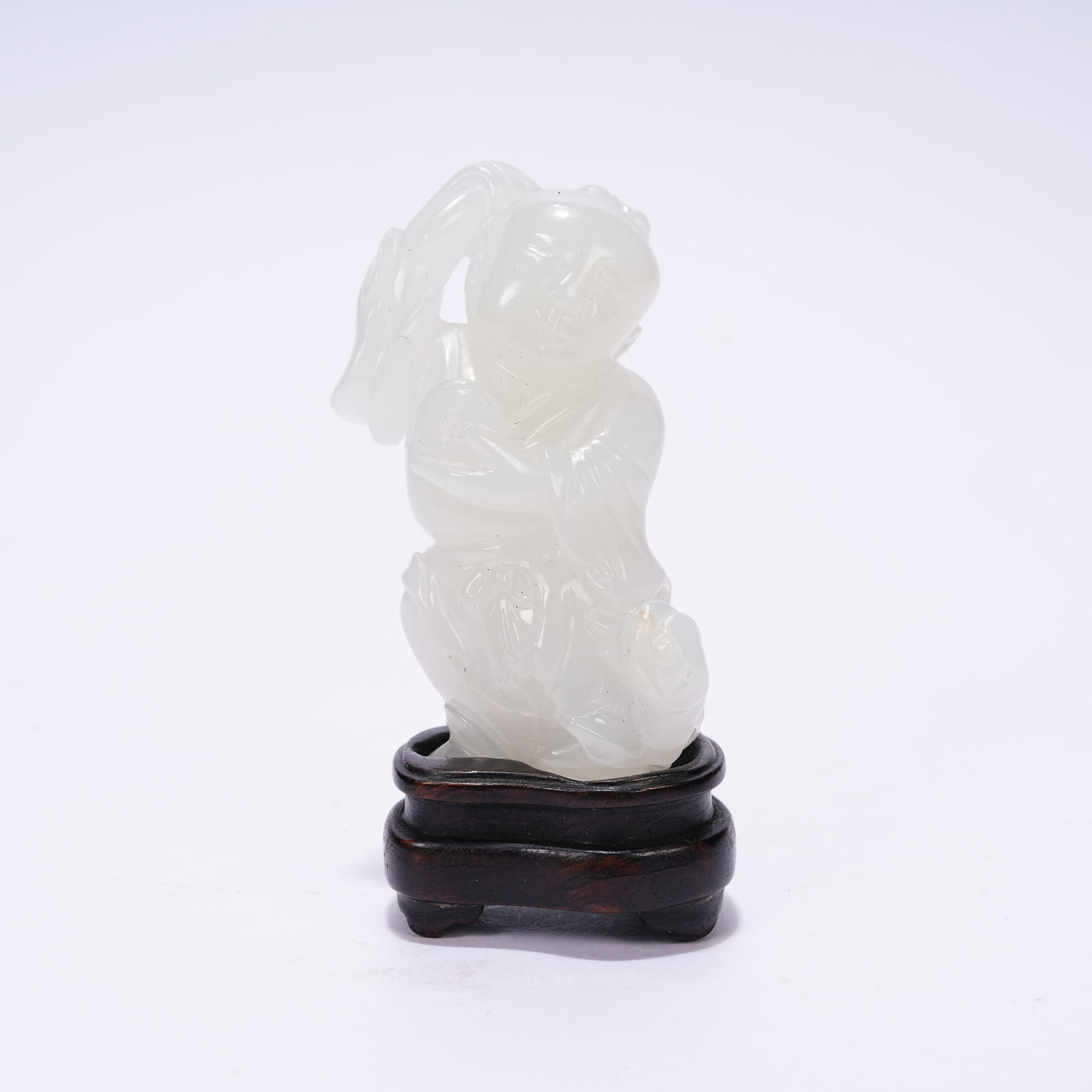 A WHITE HETIAN JADE KID HOLDING LOTUS ORNAMENT: White Hetian Jade Kid Holding Lotus Ornament