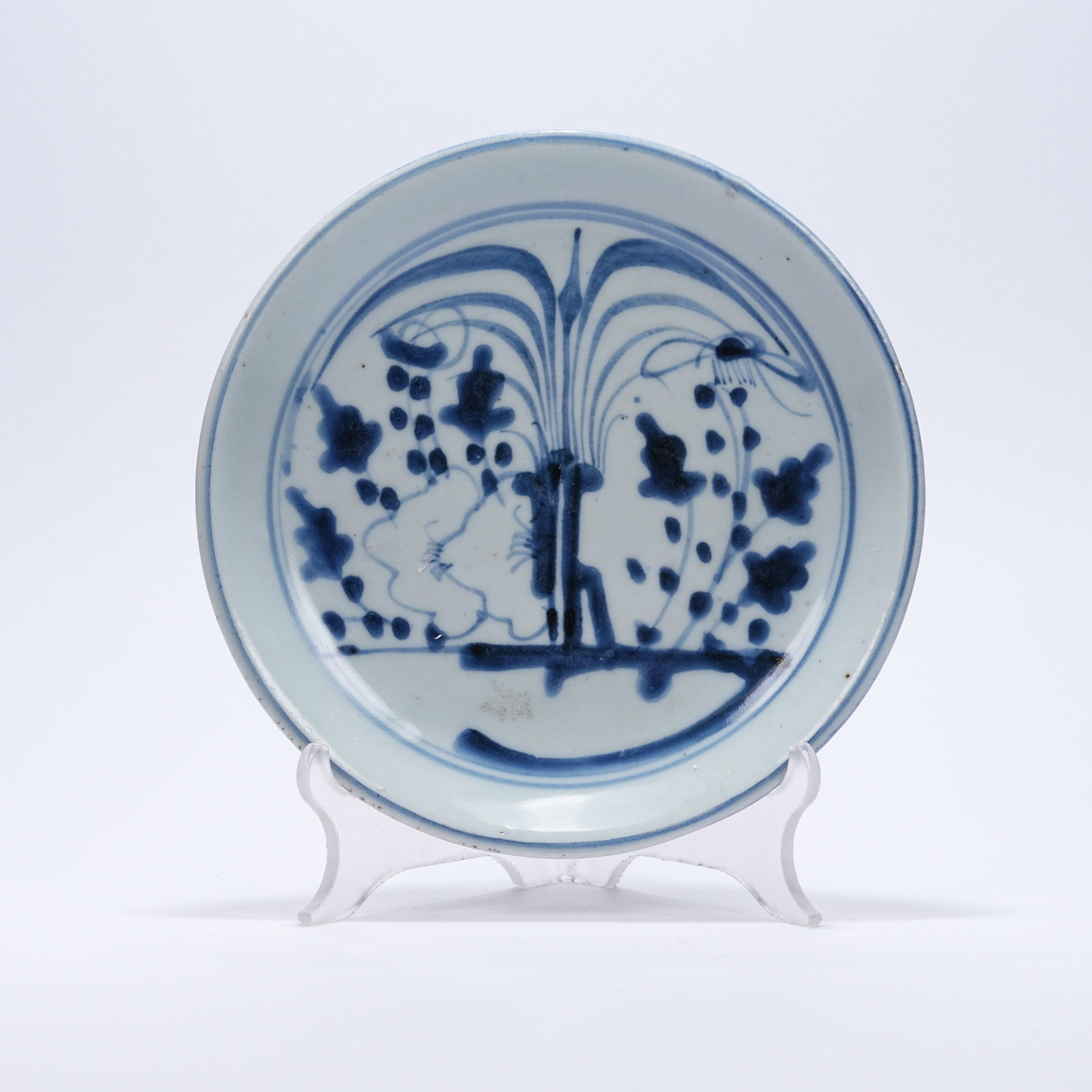 A BLUE AND WHITE PLATE WITH FLOWER AND GRASS PATTERNS: Blue and White Plate with Flower and Grass Patterns