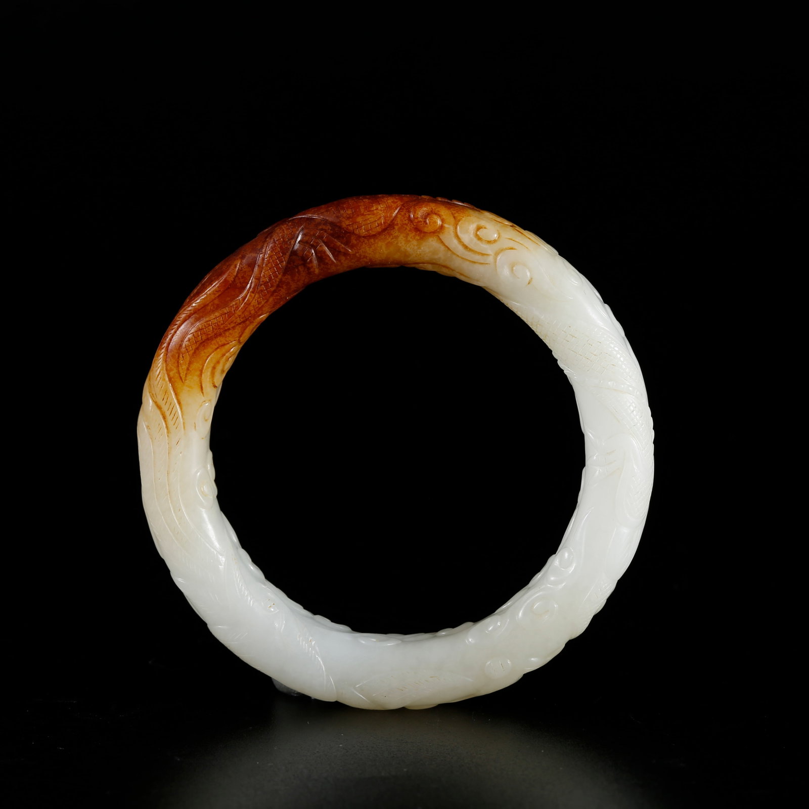 A HETIAN JADE BRACELET CARVED WITH DRAGON PATTERNS: Hetian Jade Bracelet Carved with Dragon Patterns
