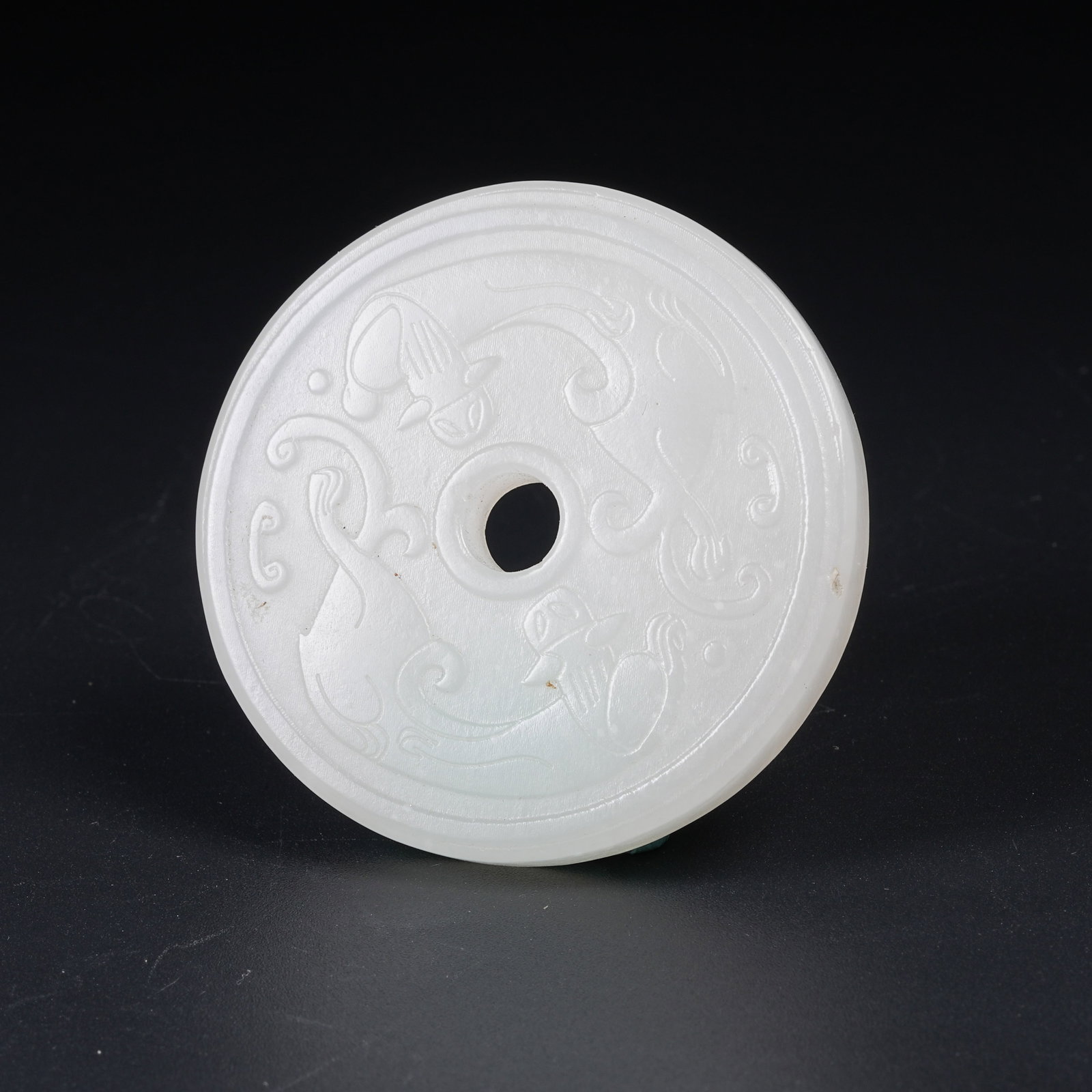 A WHITE HETIAN JADE BI DISC CARVED WITH CHI DRAGON PATTERN: White Hetian Jade Bi Disc Carved with Chi Dragon Pattern