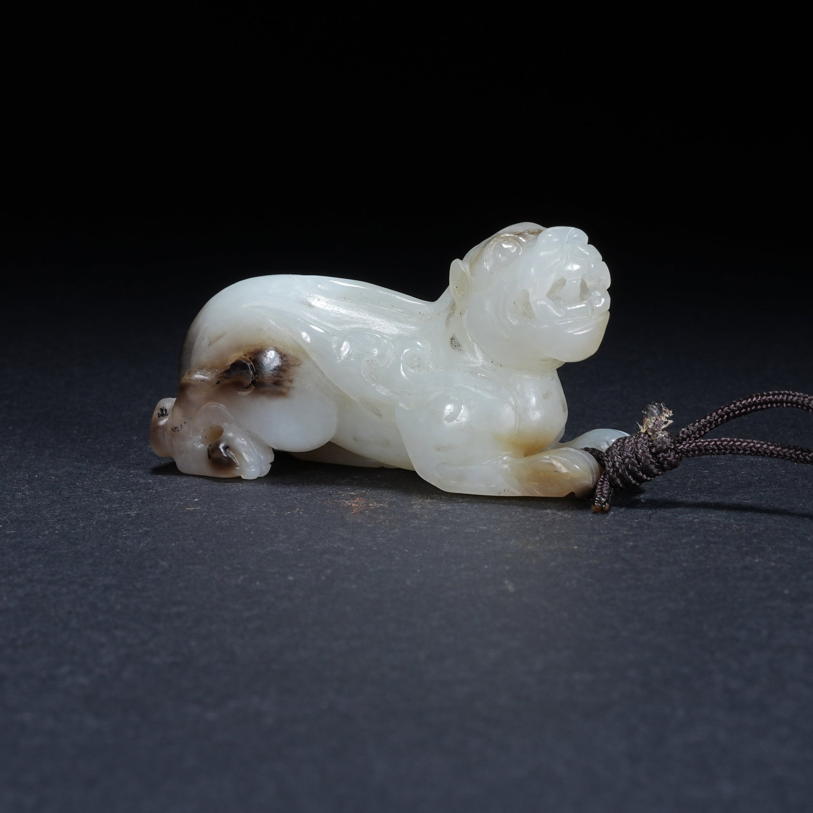 A HETIAN JADE SKILLFULLY COLORED AUSPICIOUS BEAST PENDANT: Hetian Jade Skillfully Colored Auspicious Beast Pendant