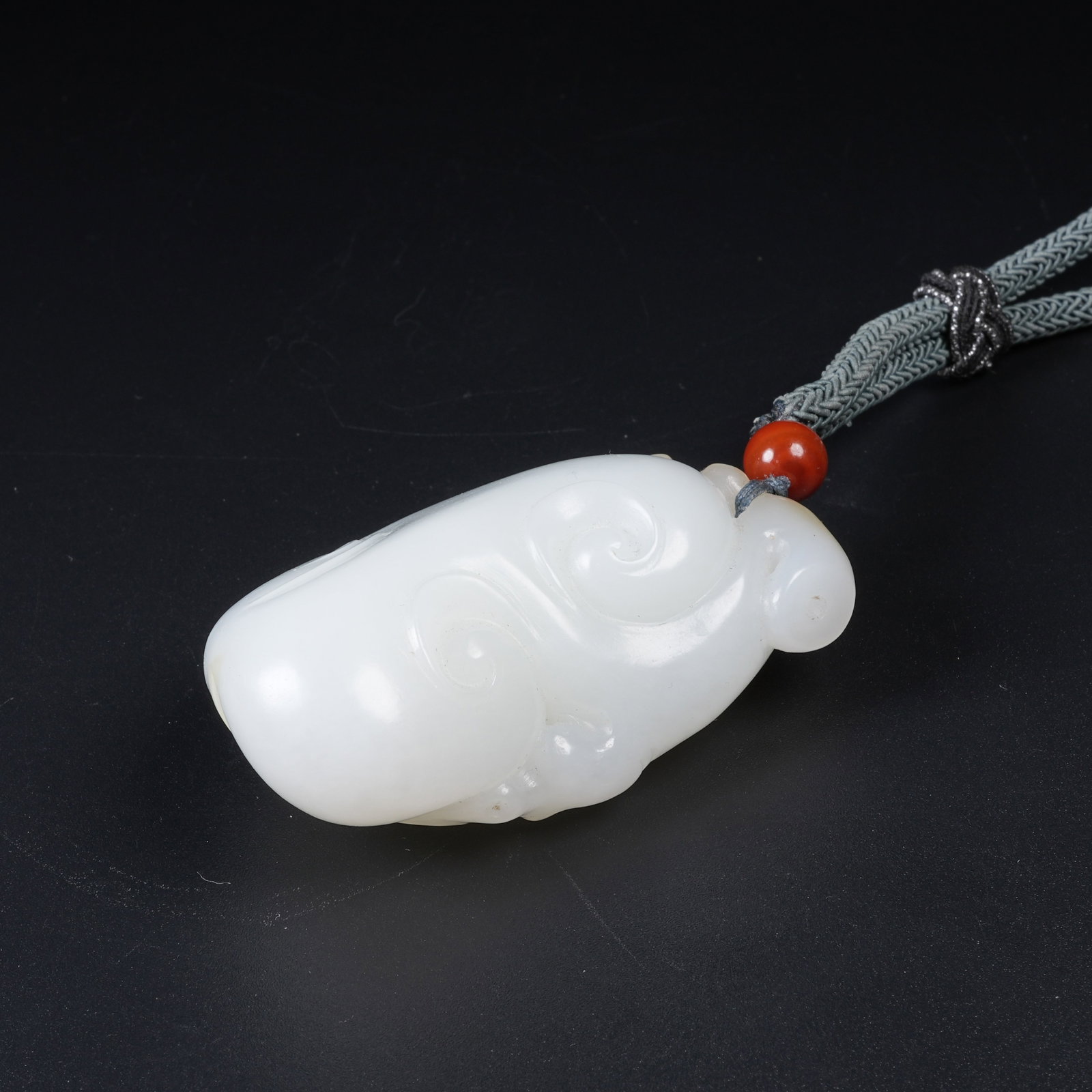A WHITE HETIAN JADE GANODERMA PENDANT: White Hetian Jade Ganoderma Pendant