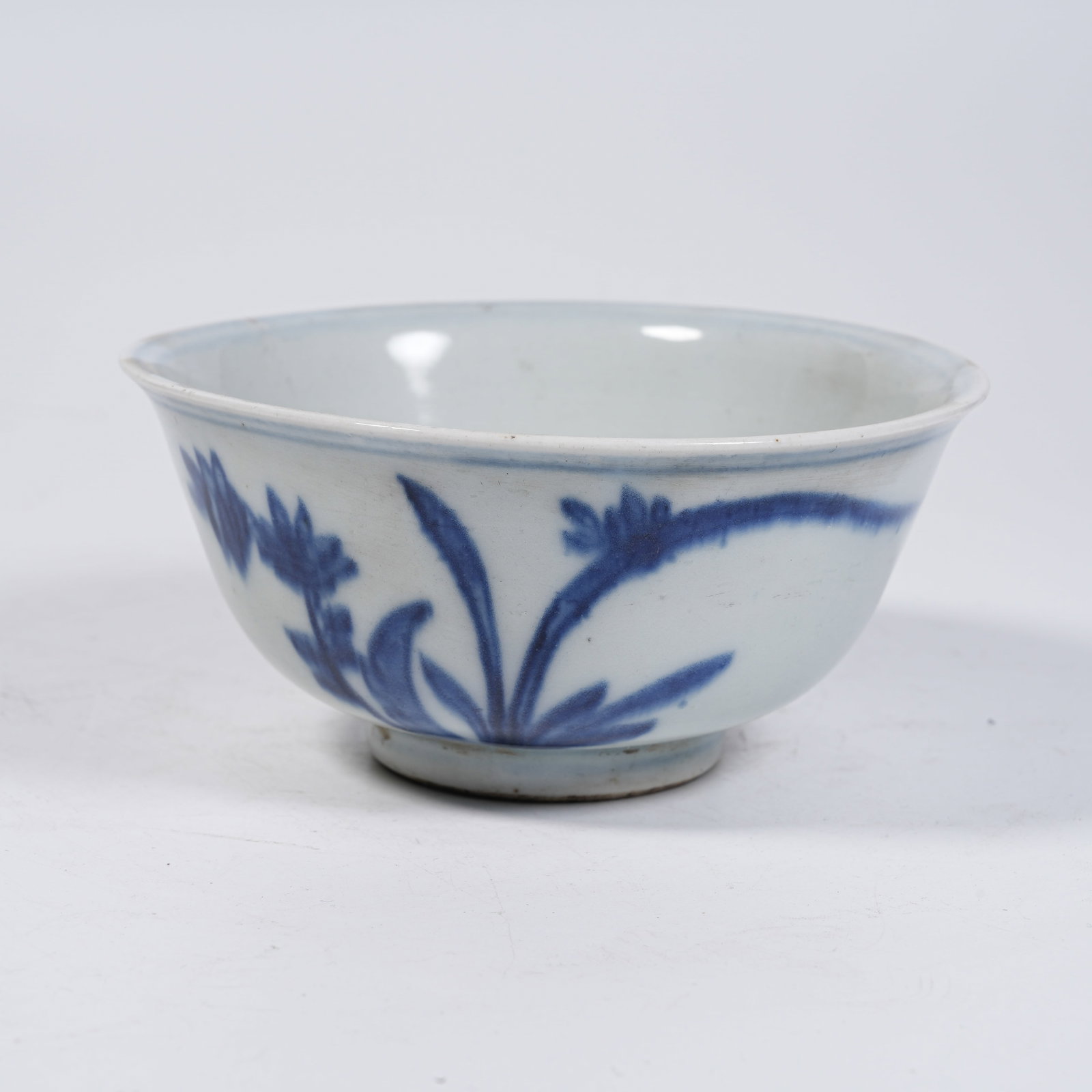 A BLUE AND WHITE BOWL WITH FLOWER AND BUTTERFLY PATTERNS: Blue and White Bowl with Flower and Butterfly Patterns