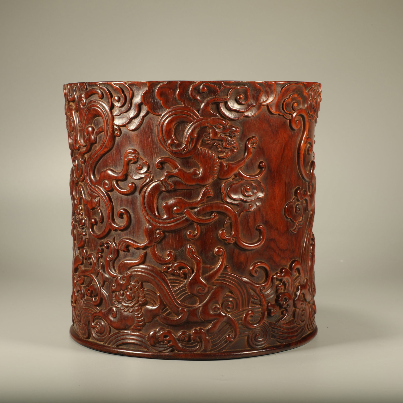 A HUANGHUALI WOOD BRUSH POT CARVED WITH WAVES AND DRAGON PATTERNS: Huanghuali Wood Brush Pot Carved with Waves and Dragon Patterns