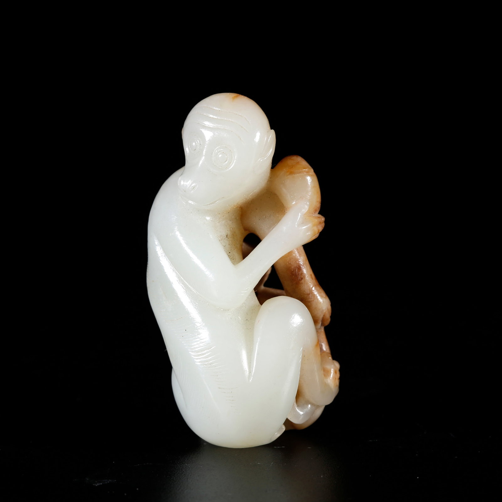 A HETIAN JADE ORNAMENT CARVED WITH SPIRITUAL MONKEY PRESENTING LONGEVITY MOTIF: Hetian Jade Ornament Carved with Spiritual Monkey Presenting Longevity Motif