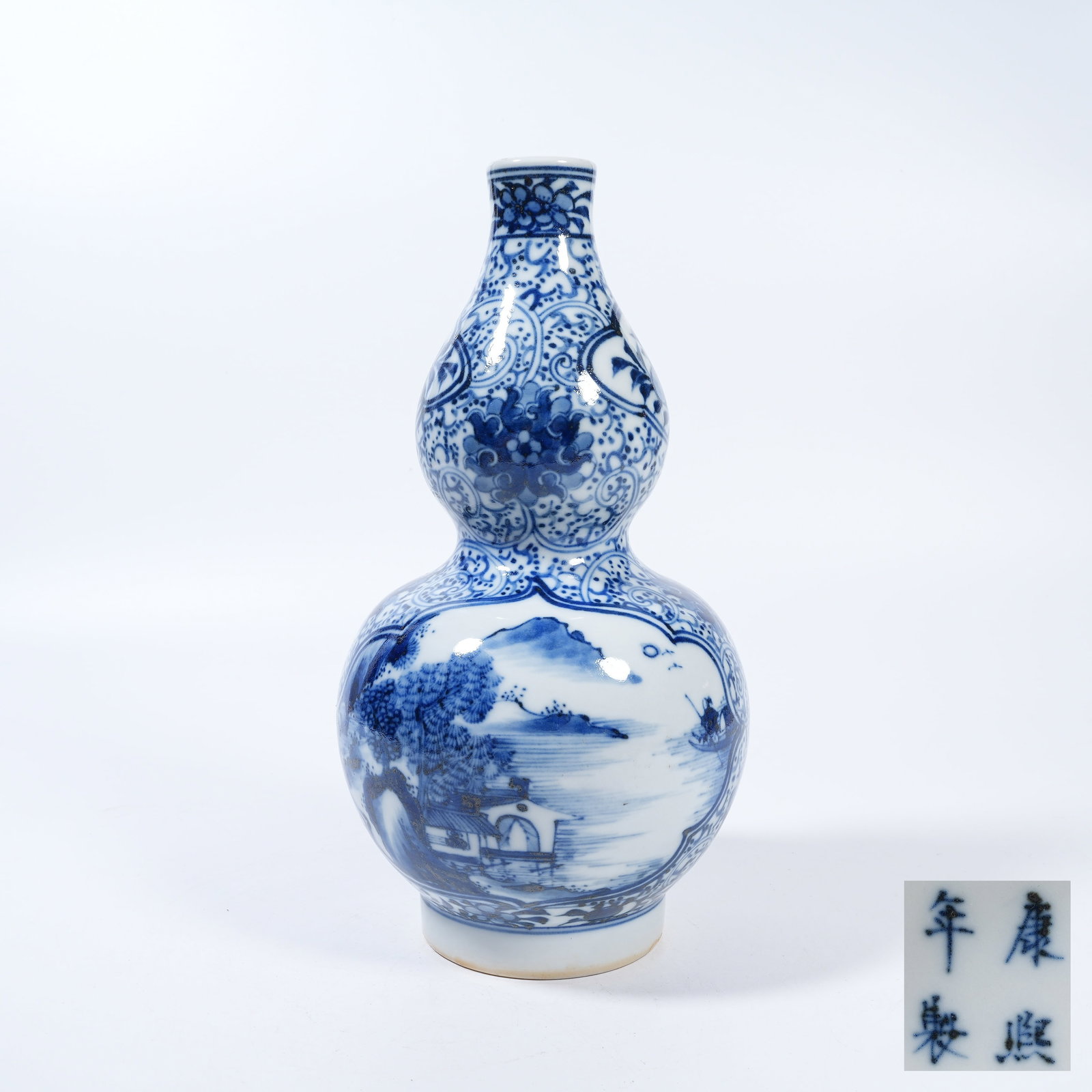 A BLUE AND WHITE GOURD VASE WITH LANDSCAPE AND PAVILION PATTERN: Blue and White Gourd Vase with Landscape and Pavilion Pattern
