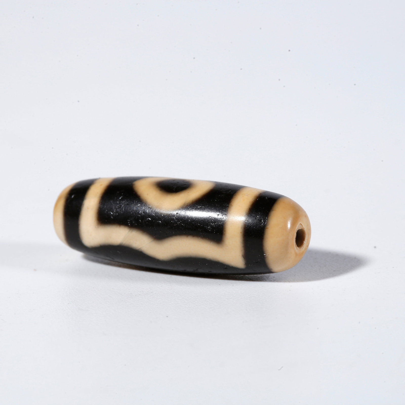 A THREE-EYED DZI BEAD: Three-Eyed Dzi Bead
