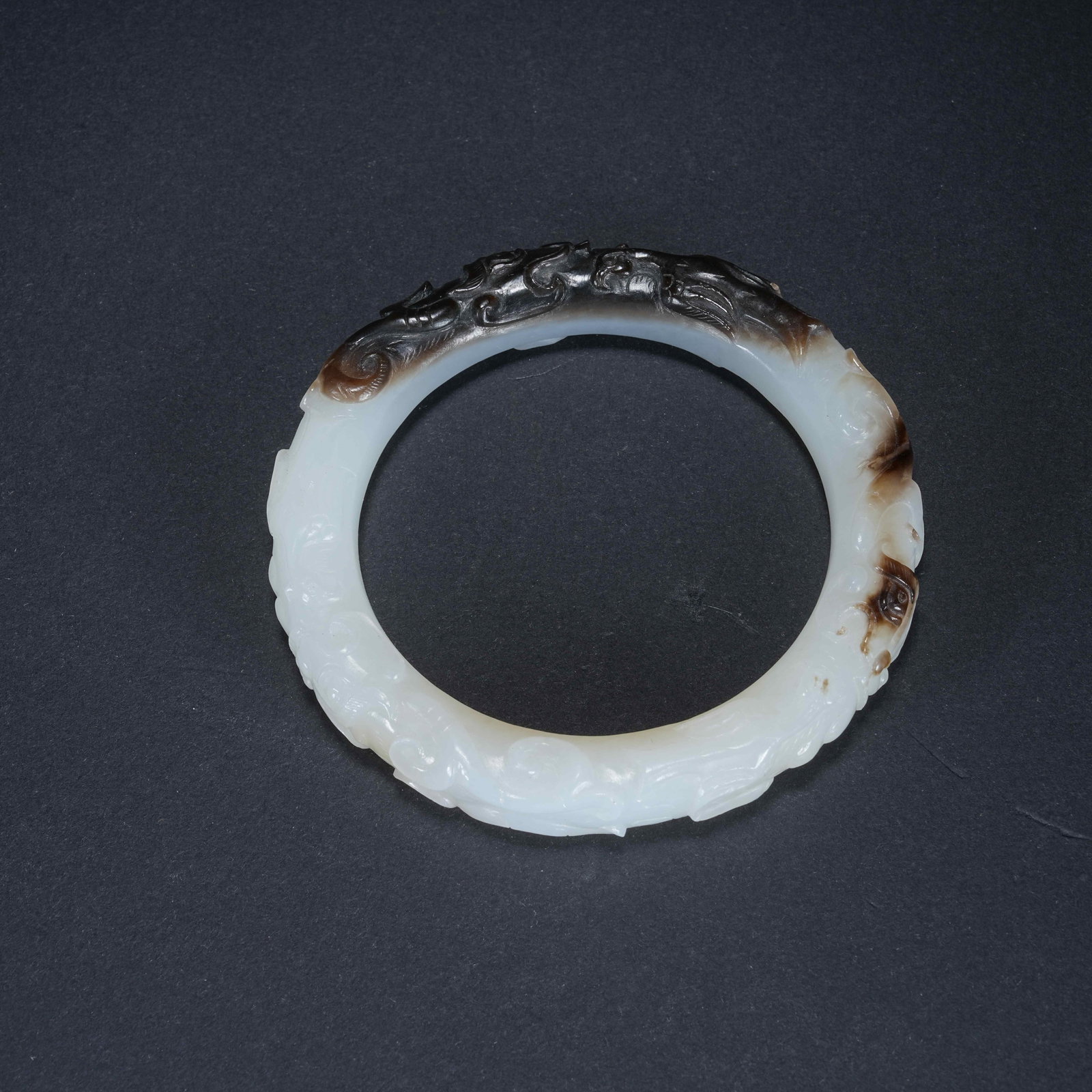 A HETIAN JADE BANGLE WITH SKILLFULLY COLORED DRAGON PATTERN (1 of 10)