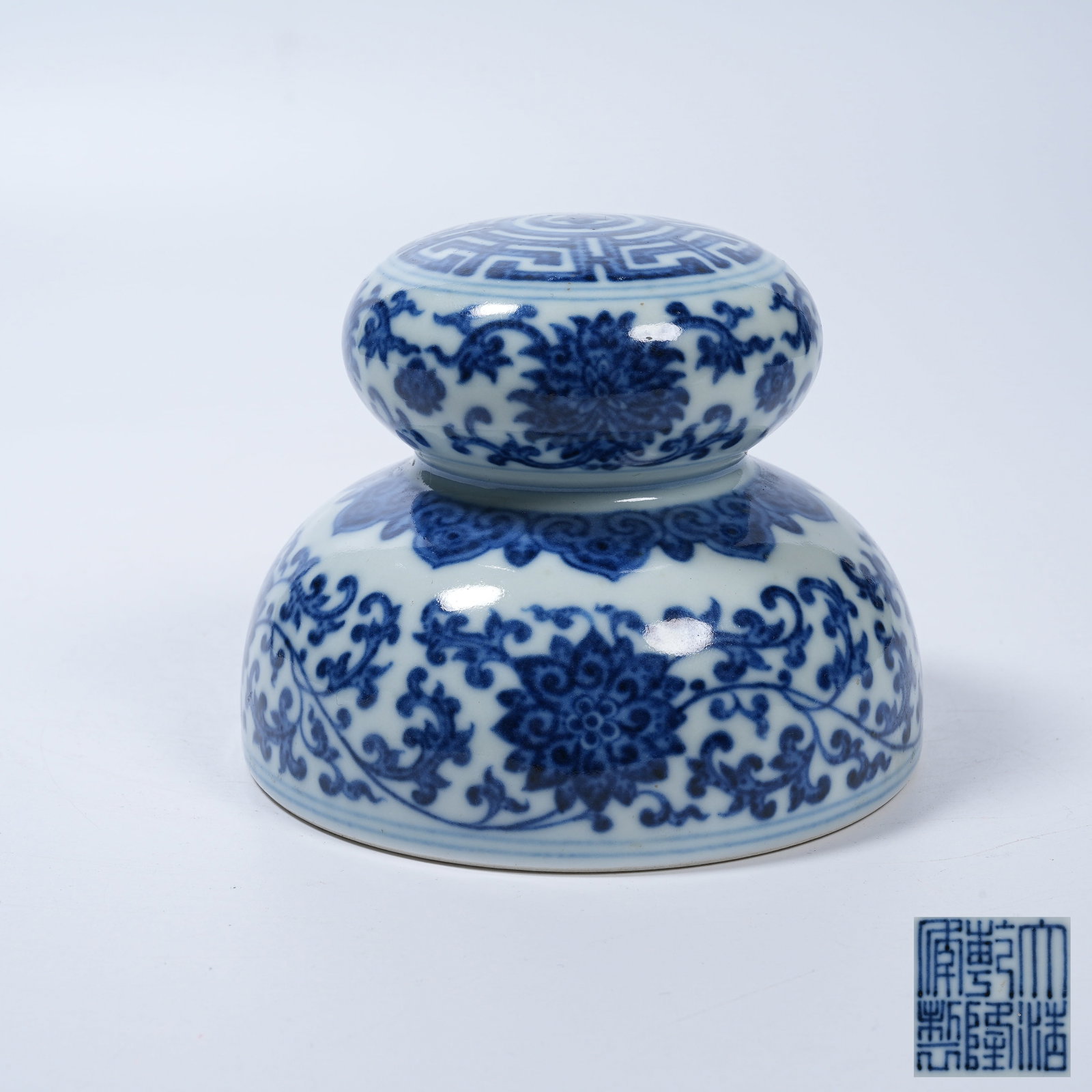 A BLUE AND WHITE PAPERWEIGHT WITH INTERLOCKING LOTUS SCROLLS (1 of 9)