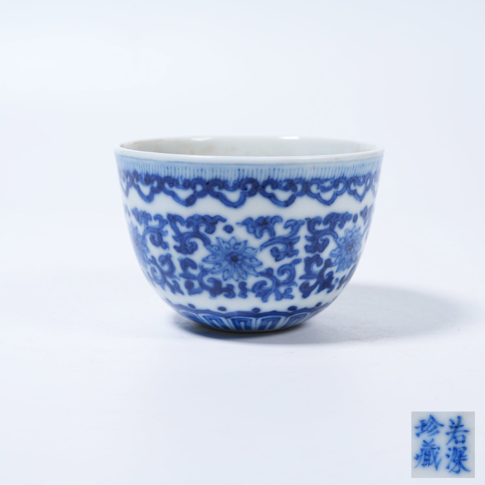 A BLUE AND WHITE CUP WITH INTERLOCKING FLORAL SCROLLS (1 of 9)